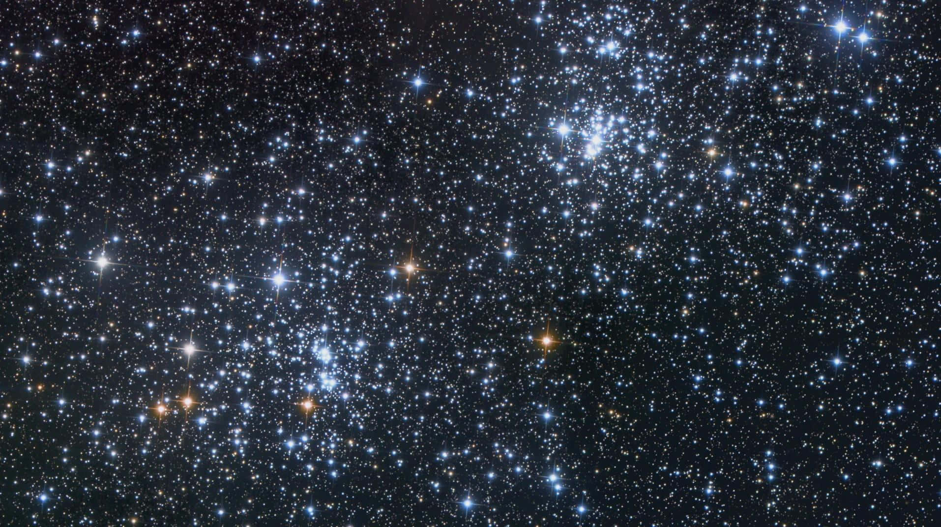 宇宙 桌布 壁紙 — 一個令人嘆為觀止的密集星團景象，藍色和橙色的星星在深邃的黑色宇宙虛空中閃耀。
