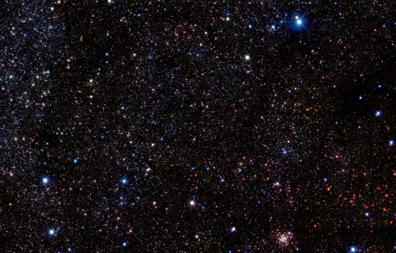Star Cluster 桌布 壁紙 — 一個令人嘆為觀止的密集星場，無數閃爍的星星呈現藍色、紅色和白色色調，映襯著深邃的黑色宇宙背景。