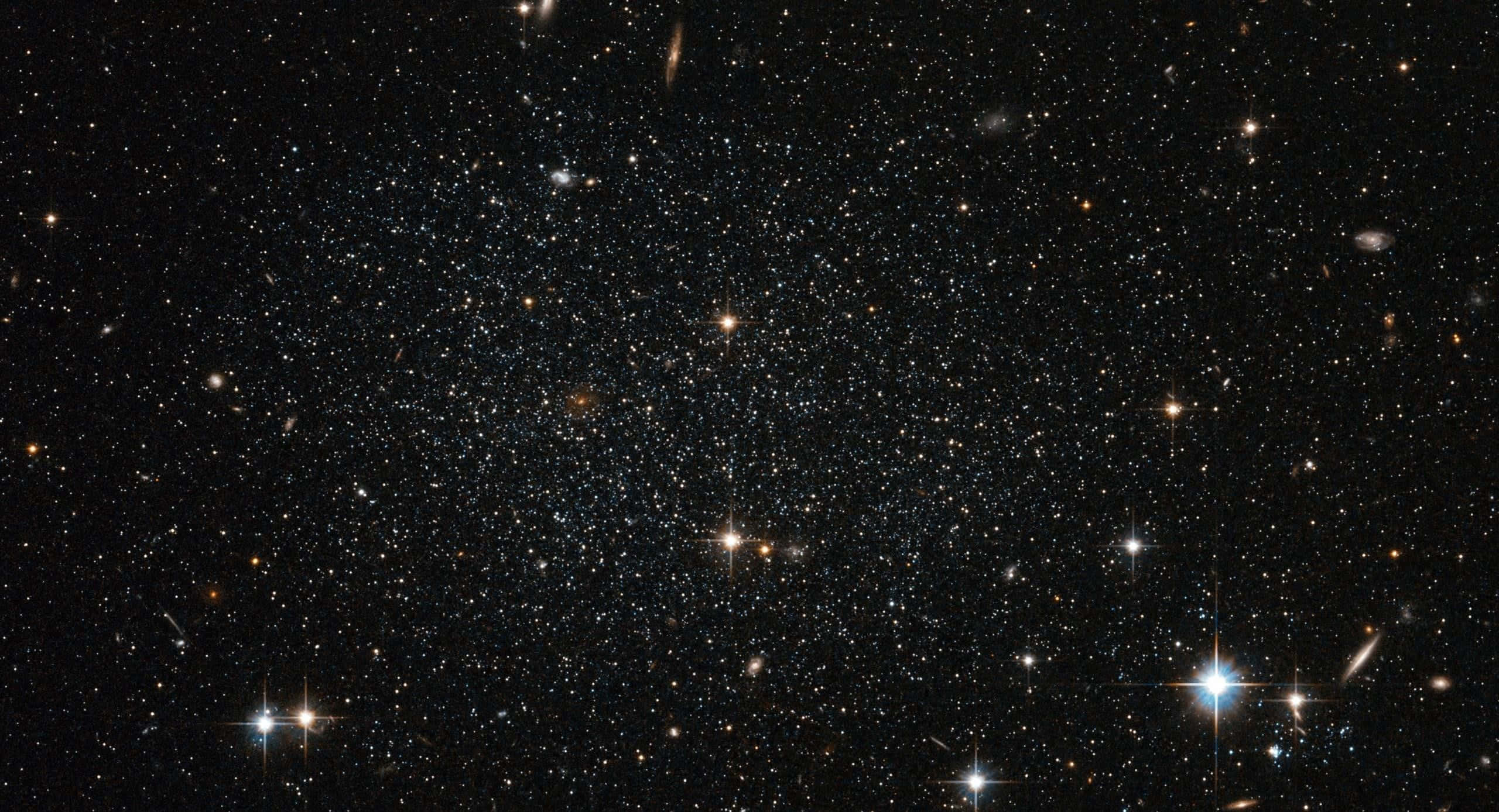 Dark Galaxy 桌布 壁紙 — 一個令人嘆為觀止的密集星場景觀，明亮的閃爍星星和遙遠的星系襯托著深邃的黑色宇宙虛空。