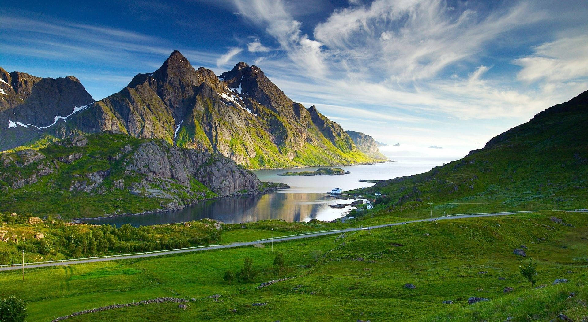 風景 桌布 壁紙 — 一個令人嘆為觀止的峽灣，坐落在高聳的綠色山脈之間，上方是明亮的藍天和縷縷薄雲。