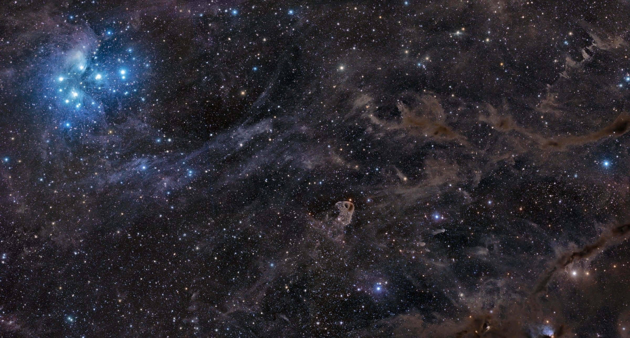 酷炫太空 桌布 壁紙 — 一個令人嘆為觀止的星空景象，發光的藍色星雲和旋轉的宇宙塵埃在黑暗虛空中展現。