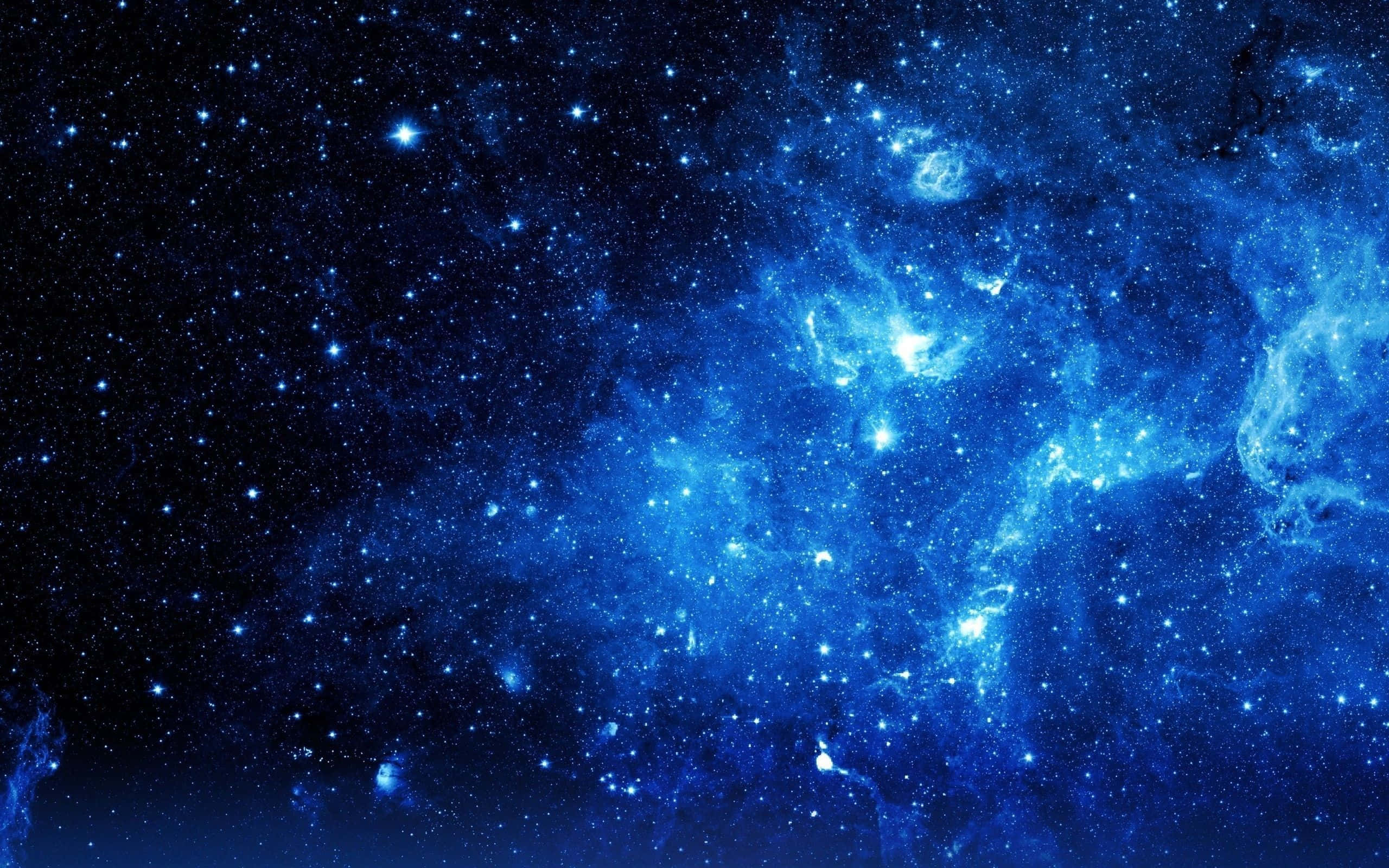 藍色銀河 桌布 壁紙 — 一個令人嘆為觀止的深藍色星雲，在黑暗的宇宙背景下閃爍著明亮的星星。