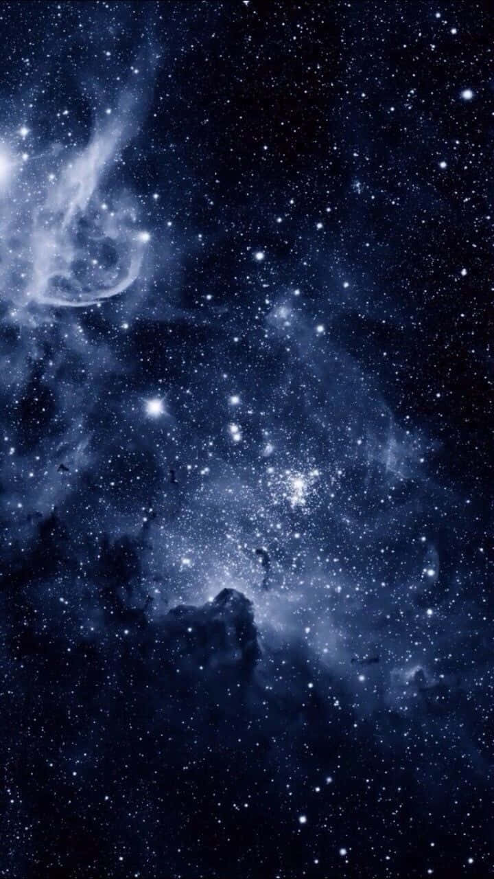 Galaxy Blue Aesthetic 桌布 壁紙 — 一個令人嘆為觀止的深藍色星雲景觀，充滿了發光的星星和宇宙塵埃雲，映襯著太空的黑暗虛空。