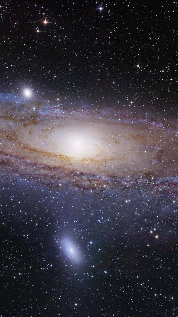 銀河 iPhone 桌布 壁紙 — 一個令人嘆為觀止的螺旋星系，在佈滿閃爍星星的星場中散發著金色和藍色的光芒。