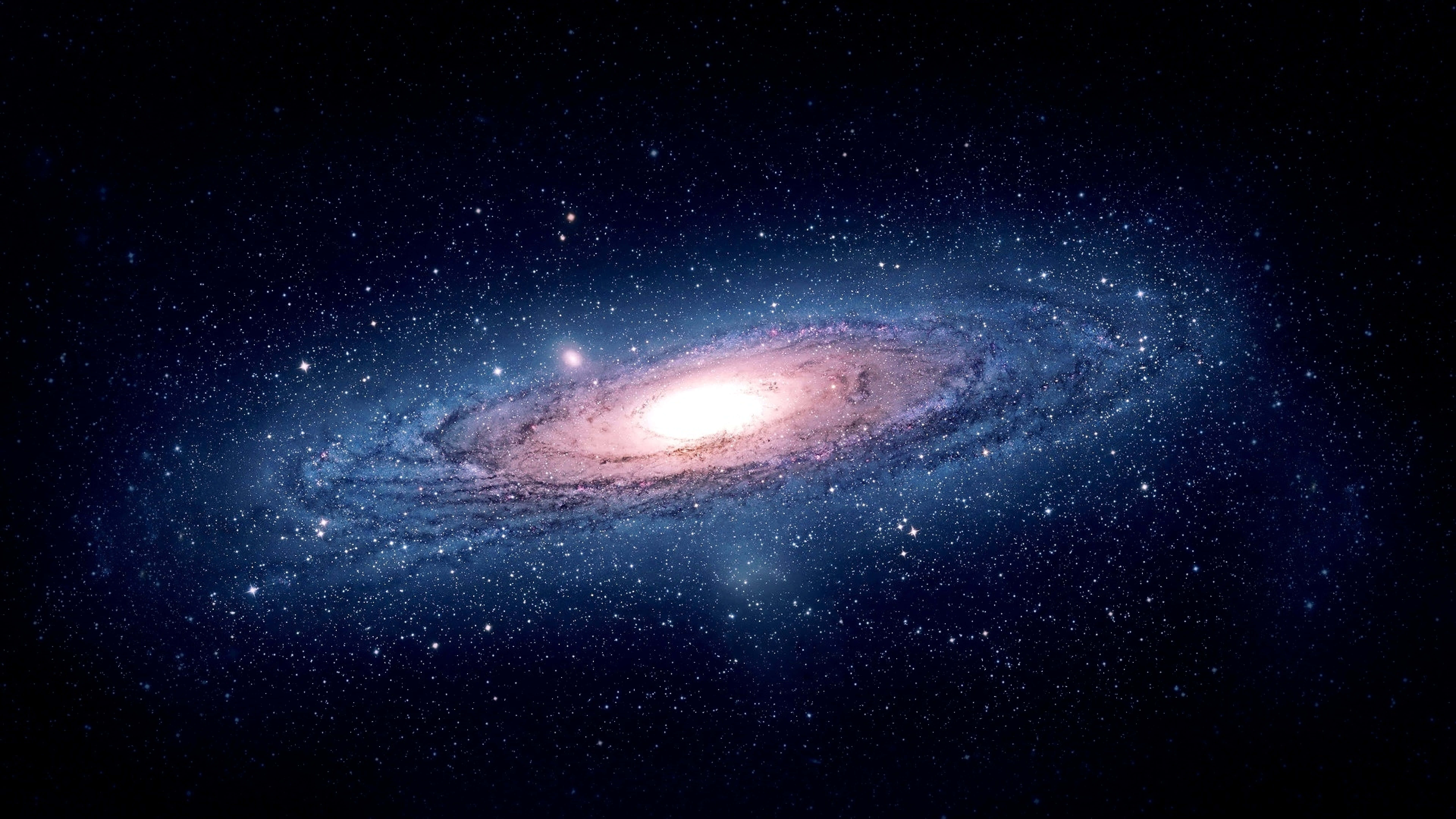 桌布 壁紙 — 一個令人嘆為觀止的螺旋星系，在星空中散發著粉紅色和藍色的光芒。