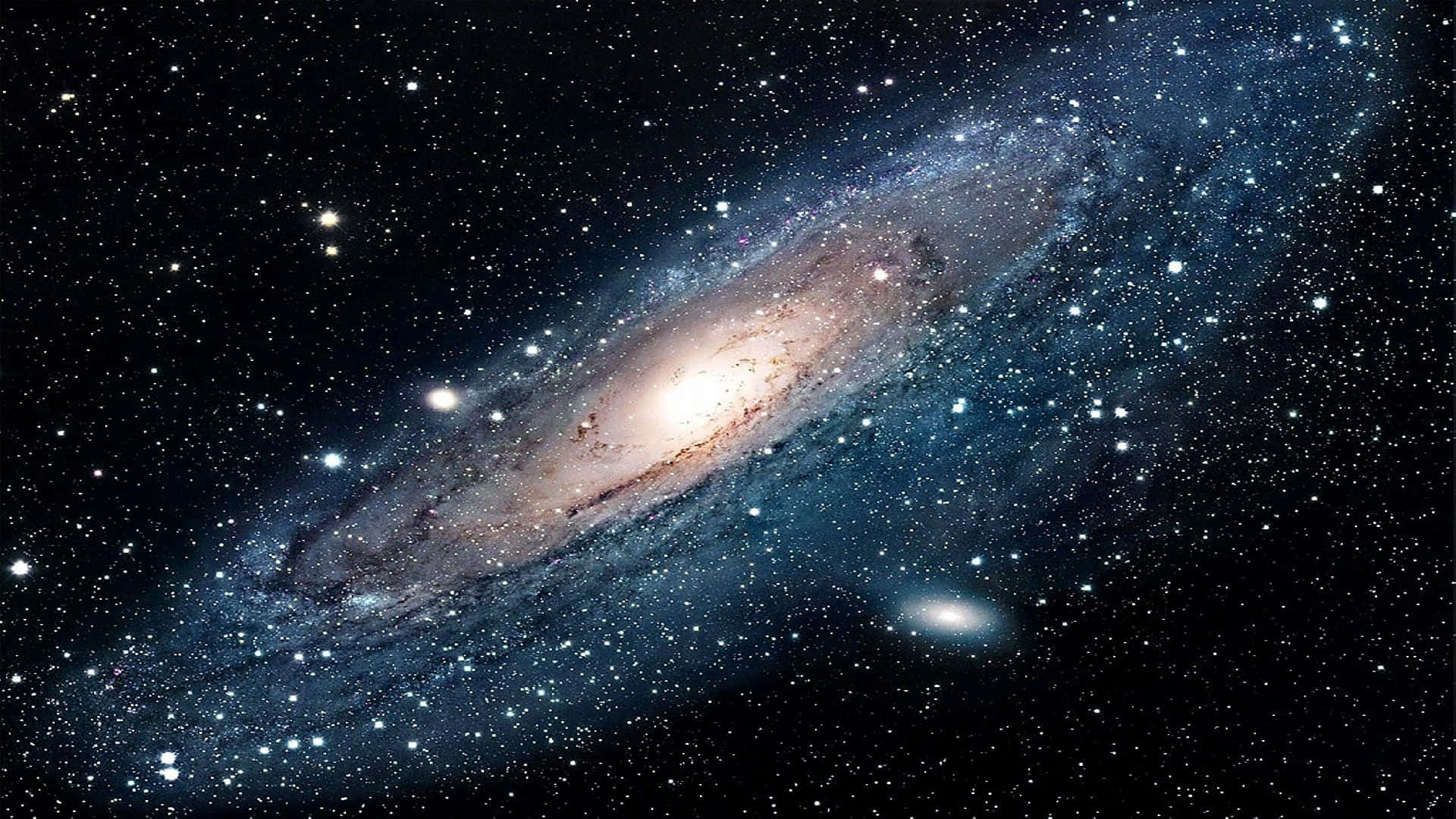 酷炫太空 桌布 壁紙 — 一個令人嘆為觀止的螺旋星系，在星空中閃耀著金色核心和藍色旋臂。