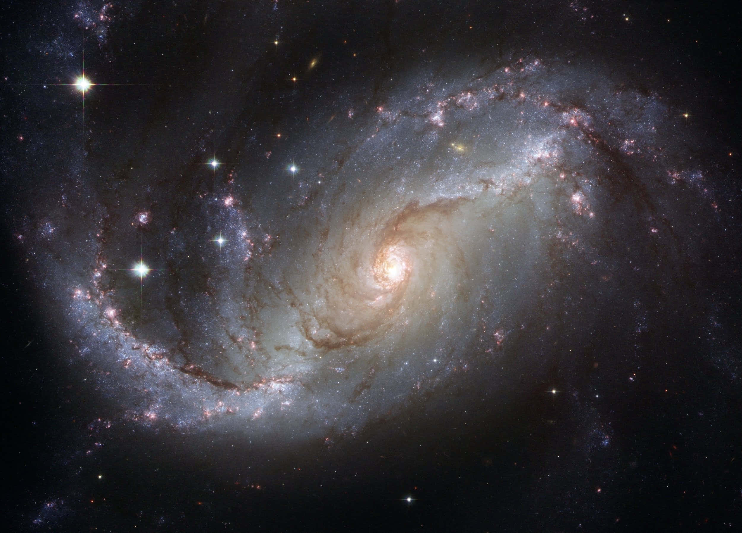 太空 桌布 壁紙 — 一個令人嘆為觀止的螺旋星系，在深邃的黑色宇宙中旋轉，散發著發光的旋臂和明亮的星星。