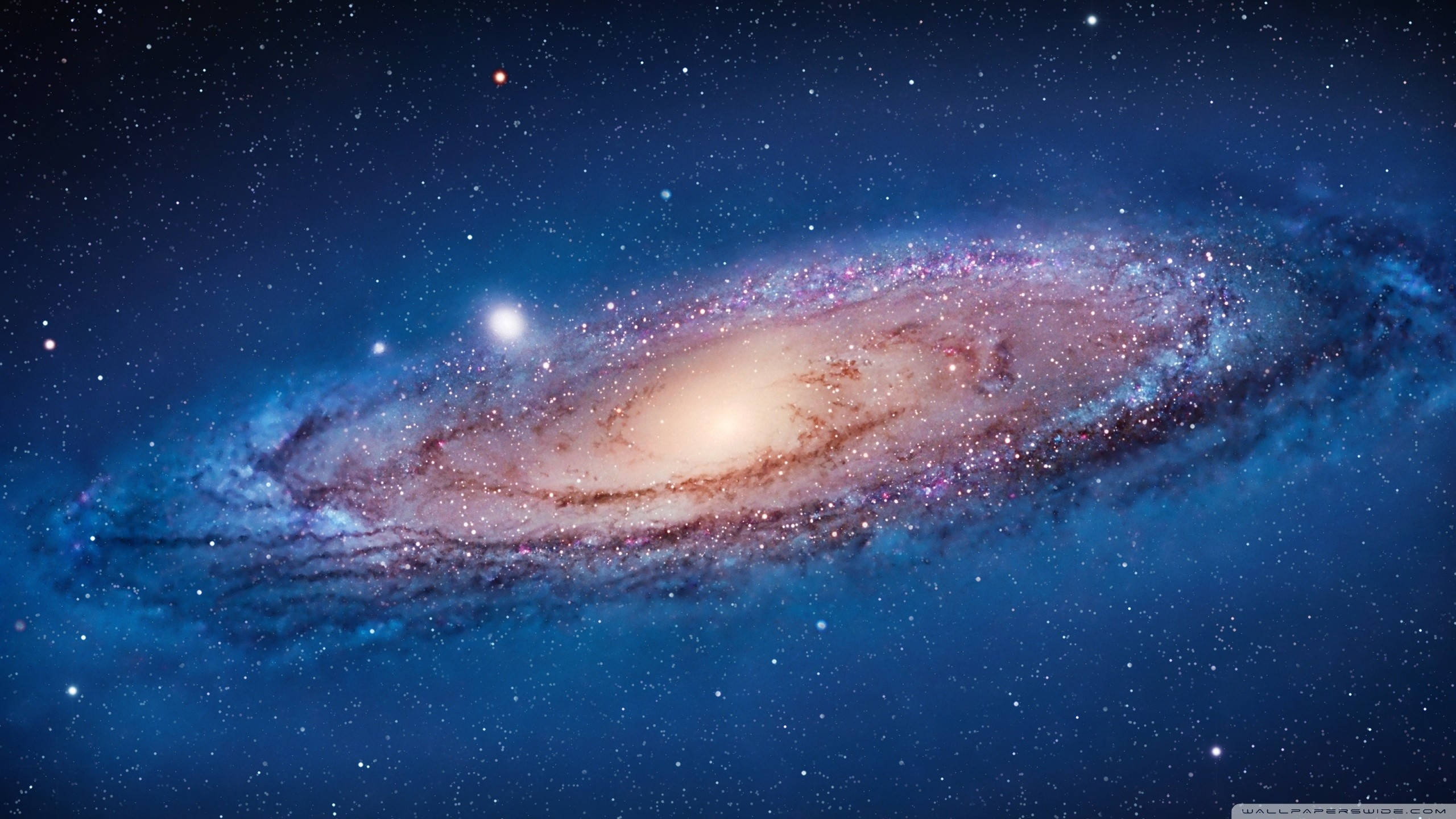 宇宙 桌布 壁紙 — 一個令人嘆為觀止的螺旋星系，在深藍色星空中閃耀著宇宙塵埃和星星。