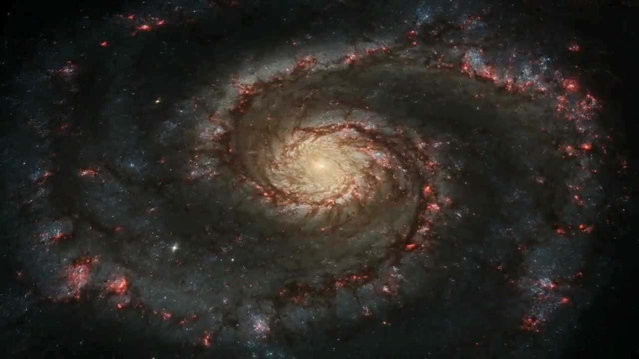 銀河 桌布 壁紙 — 一個令人嘆為觀止的螺旋星系，在深邃的黑色宇宙虛空中旋轉著發光的紅色和金色旋臂。