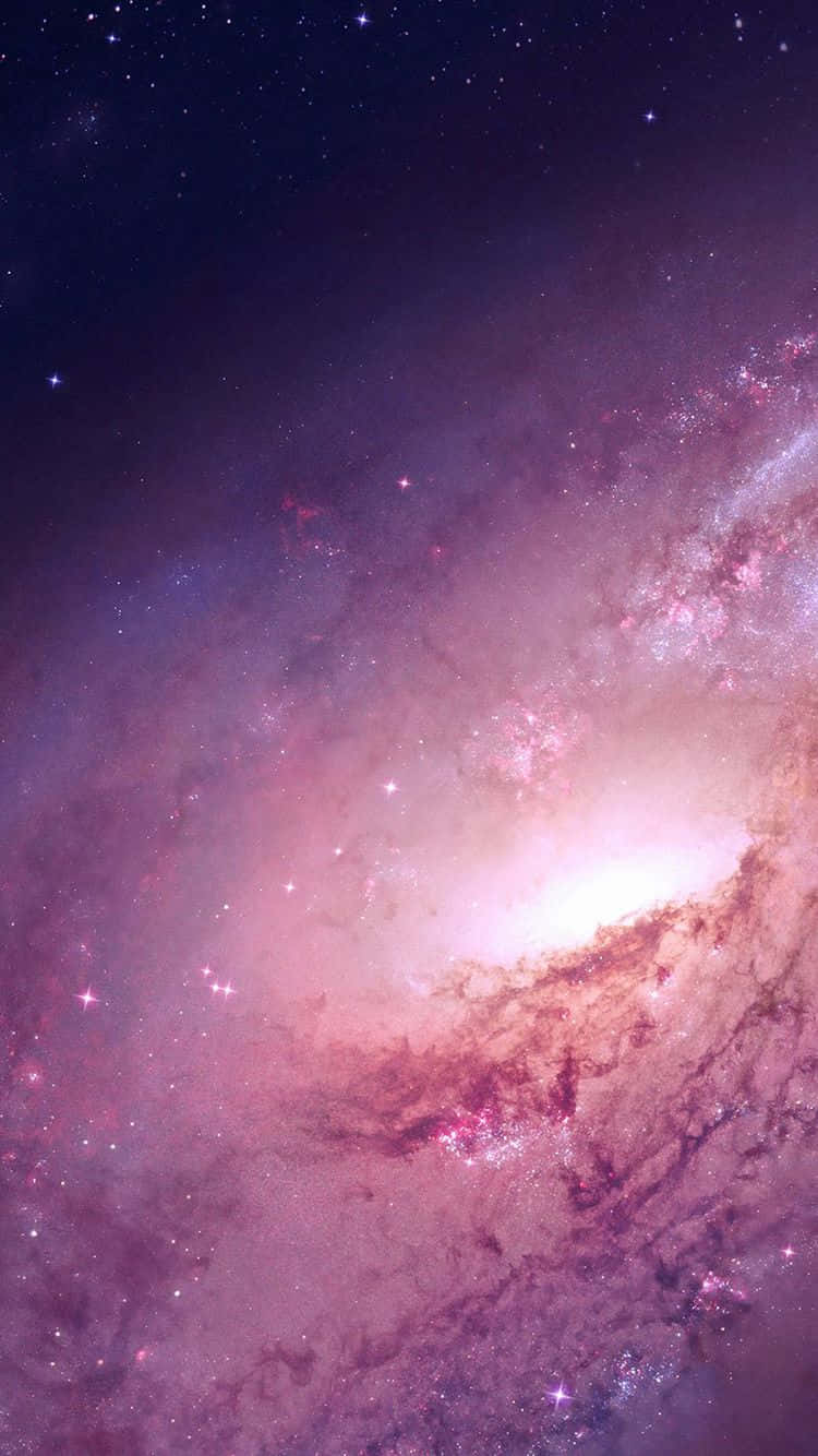 粉紅銀河 桌布 壁紙 — 一個令人嘆為觀止的螺旋星系，在繁星點點的宇宙背景下閃耀著粉紅色和紫色的星雲。