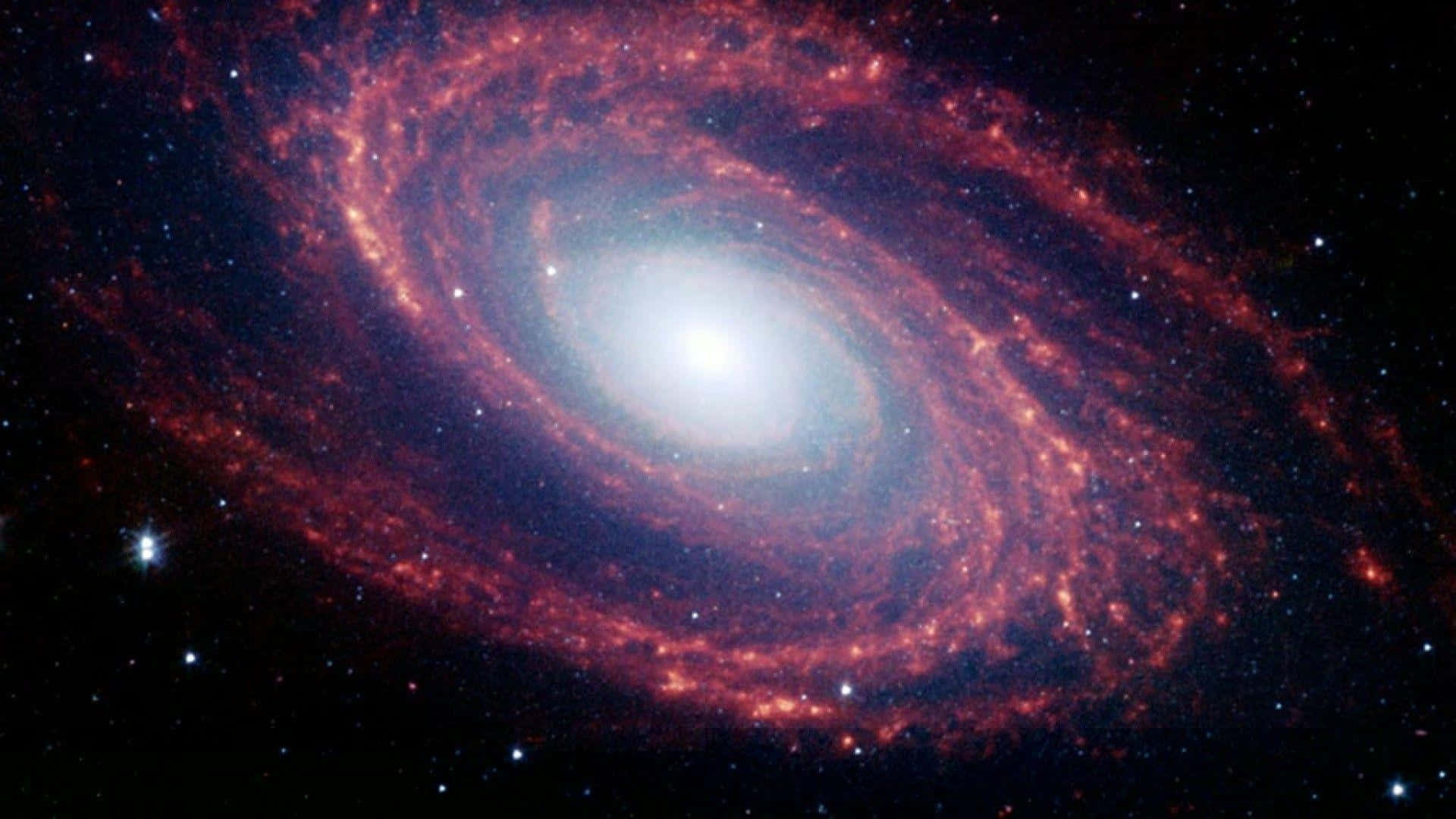 Spiral Galaxy 桌布 壁紙 — 一個令人嘆為觀止的螺旋星系，在繁星點點的宇宙虛空中散發出火紅與白色的光芒。