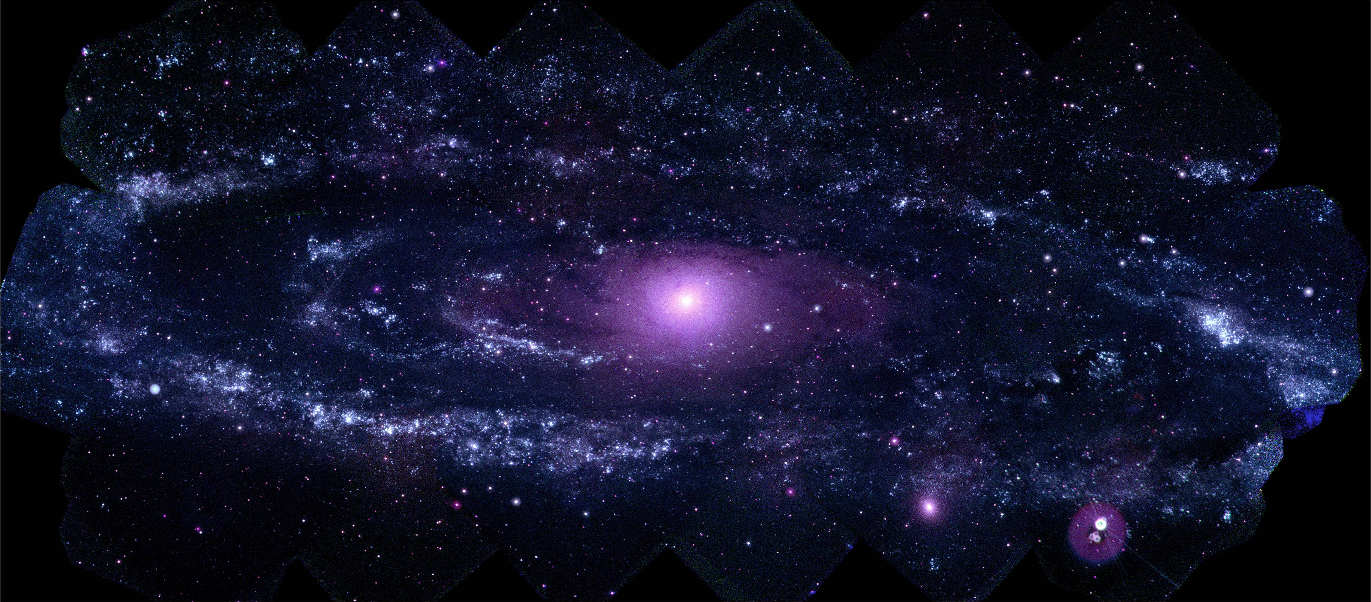 Pretty Galaxy 桌布 壁紙 — 一個令人嘆為觀止的螺旋星系，在繁星點點的宇宙背景下散發出紫色和藍色的光芒。