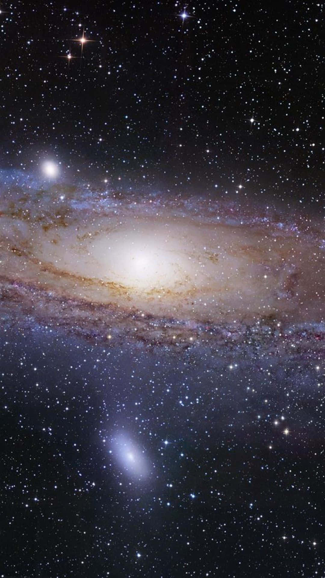 Stars 桌布 壁紙 — 一個令人嘆為觀止的螺旋星系，在繁星點點的宇宙背景下閃耀著金色和藍色的色調。