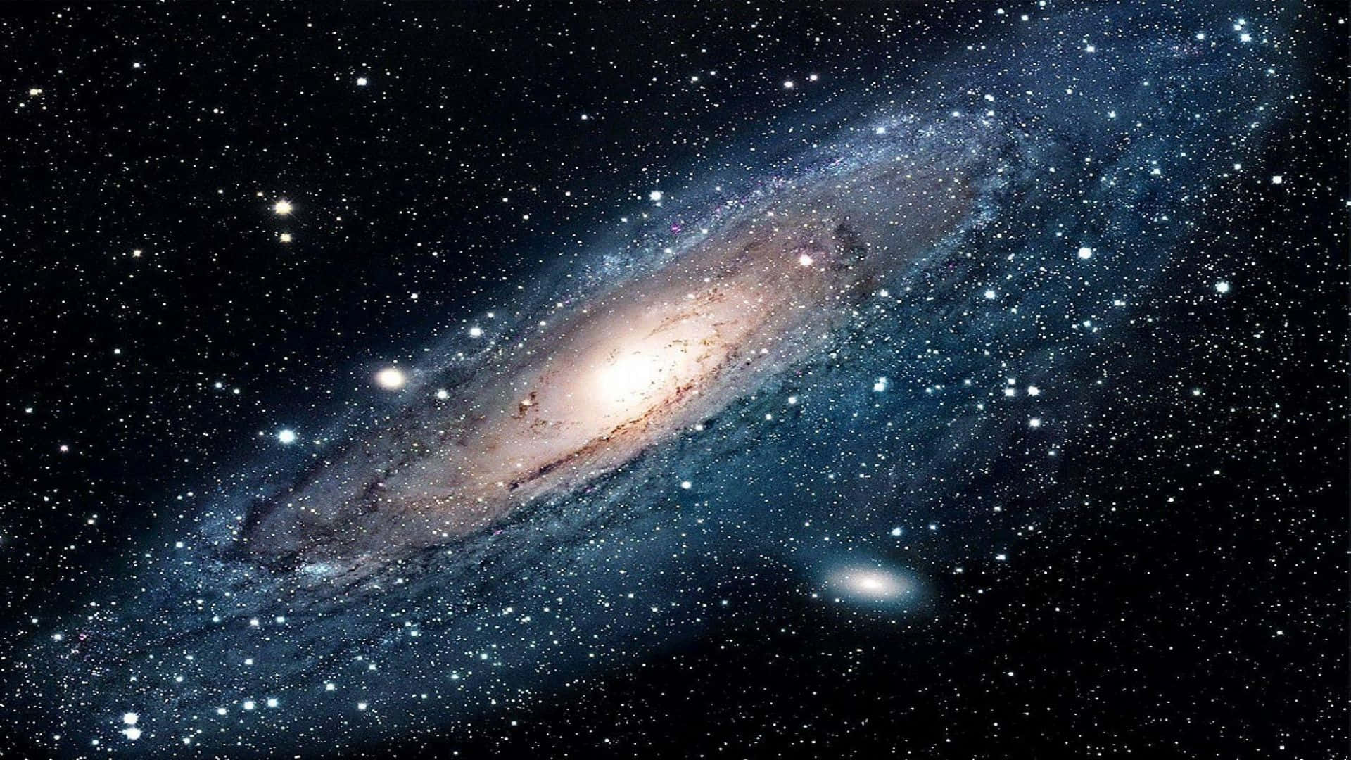 全高清 桌布 壁紙 — 一個令人嘆為觀止的螺旋星系，在繁星點點的宇宙虛空中閃耀著金色和藍色的光芒。