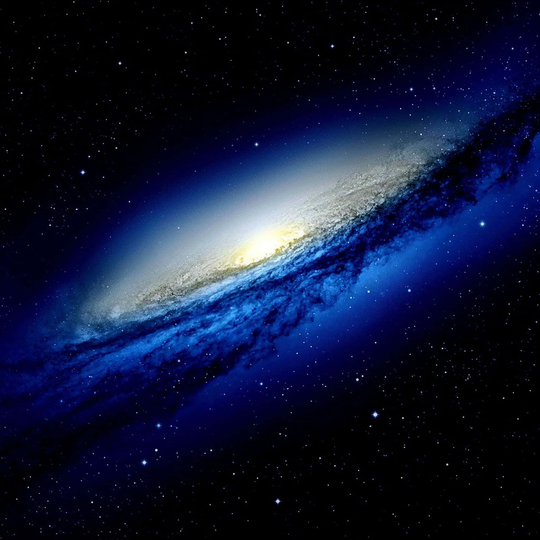 桌布 壁紙 — 一個令人嘆為觀止的螺旋星系，在繁星點點的宇宙背景下閃耀著藍色和金色的色調。