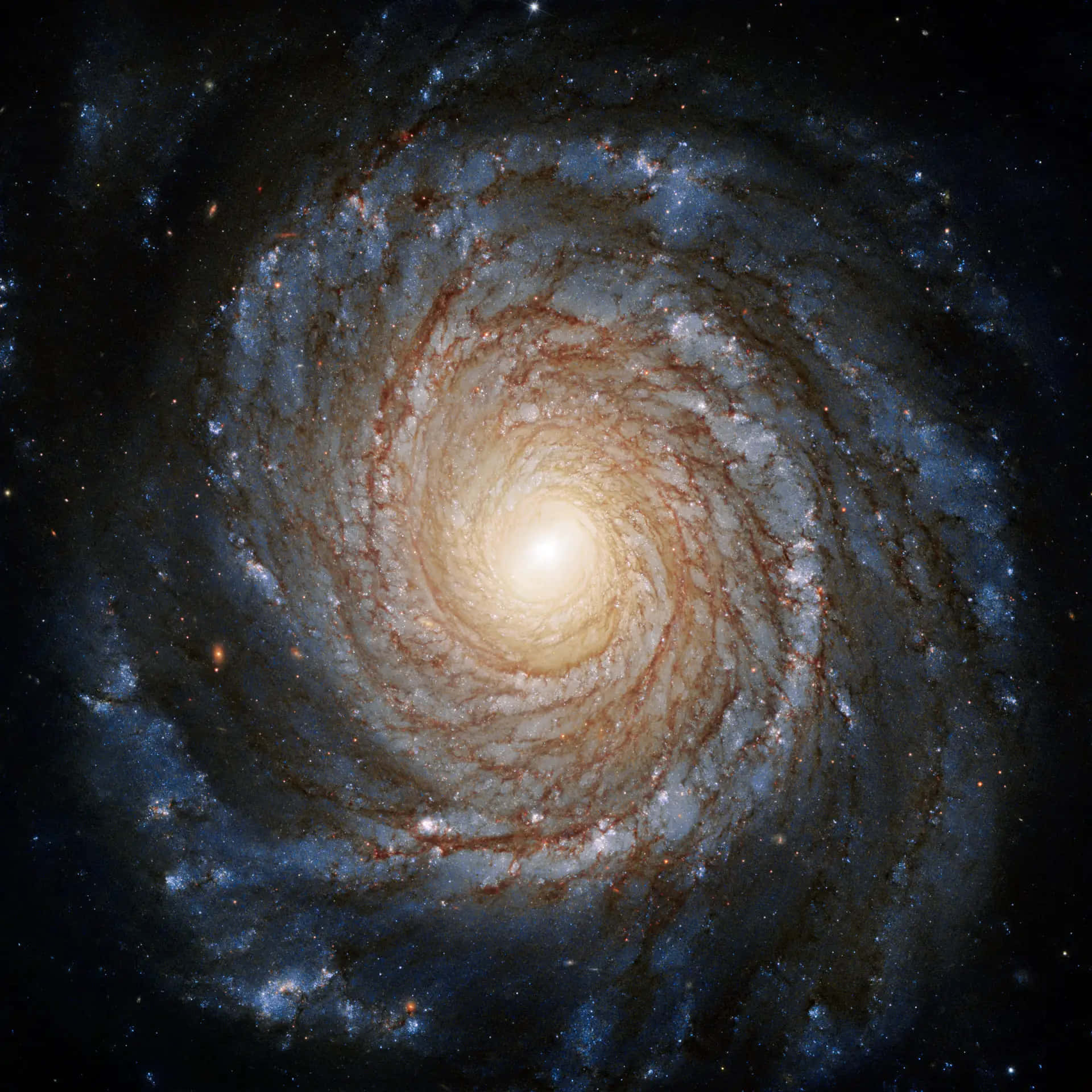 Black Hole Hubble Telescope 桌布 壁紙 — 一個令人嘆為觀止的螺旋星系，帶有熾熱的橙色核心和充滿恆星與宇宙塵埃的旋轉藍色旋臂。
