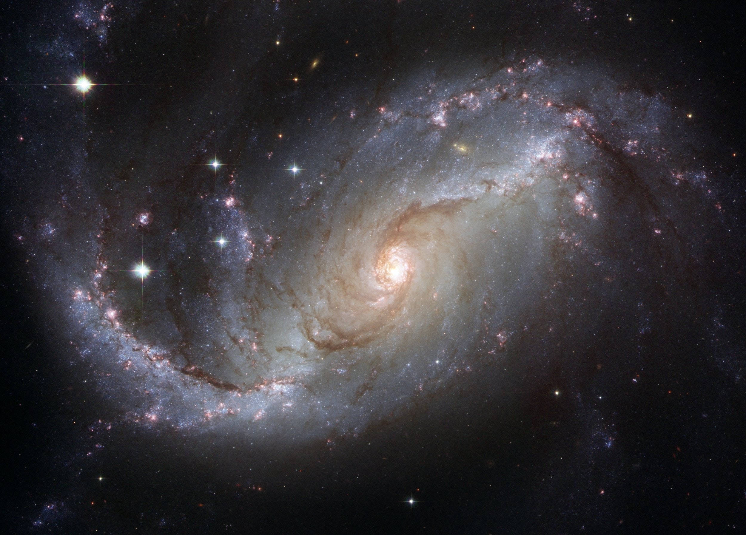 外太空 桌布 壁紙 — 一個令人嘆為觀止的螺旋星系，帶著發光的恆星和宇宙塵埃臂，在深邃的黑色太空虛空中旋轉。