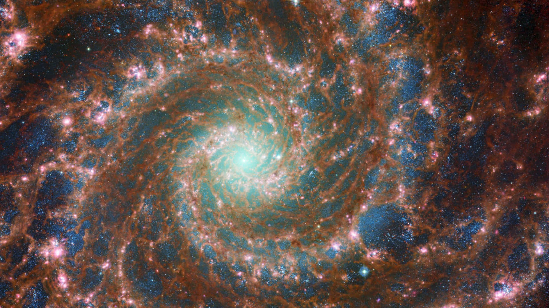 astronomy 桌布 壁紙 — 一個令人嘆為觀止的螺旋星系，擁有發光的橙色旋臂和明亮的藍綠色核心，背景是繁星點點的宇宙。