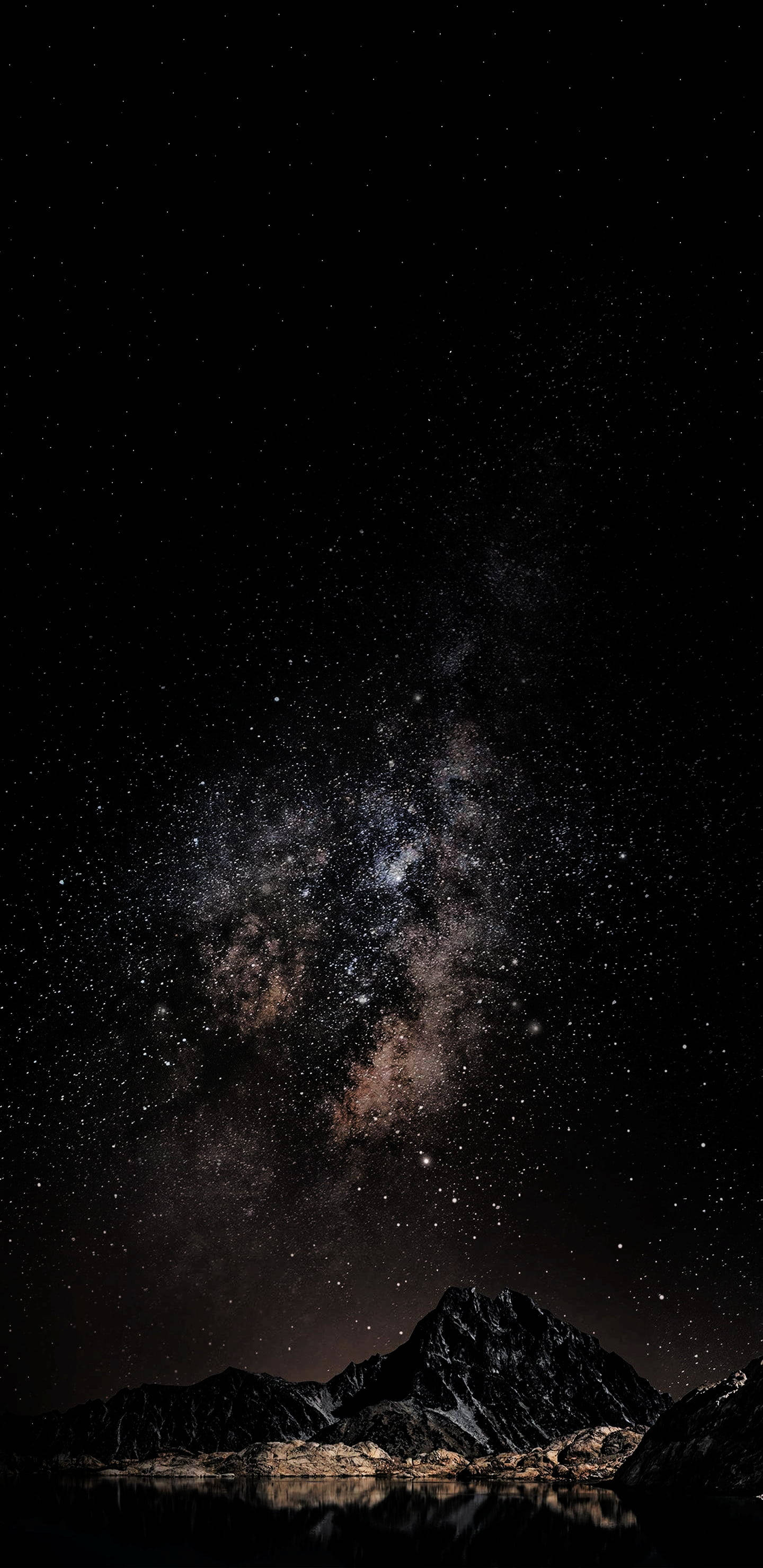 夜空 桌布 壁紙 — 一個令人屏息的夜空，佈滿星星和銀河，拱形橫跨在平靜水面倒映的黑暗山脈之上。