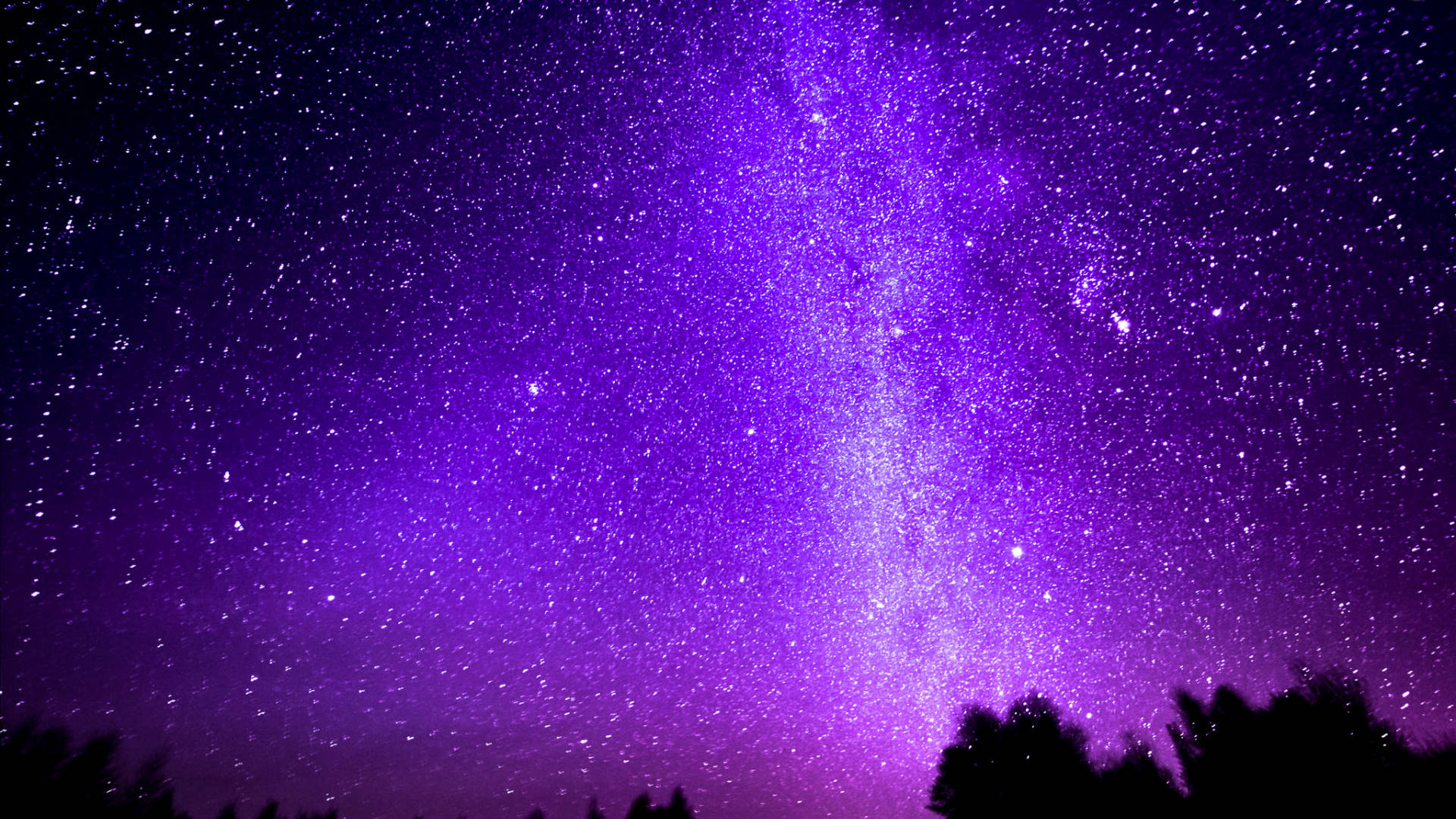 黑紫美學 桌布 壁紙 — 一個令人屏息的紫色夜空，充滿閃爍的星星和發光的銀河核心，在黑暗的樹木剪影之上。