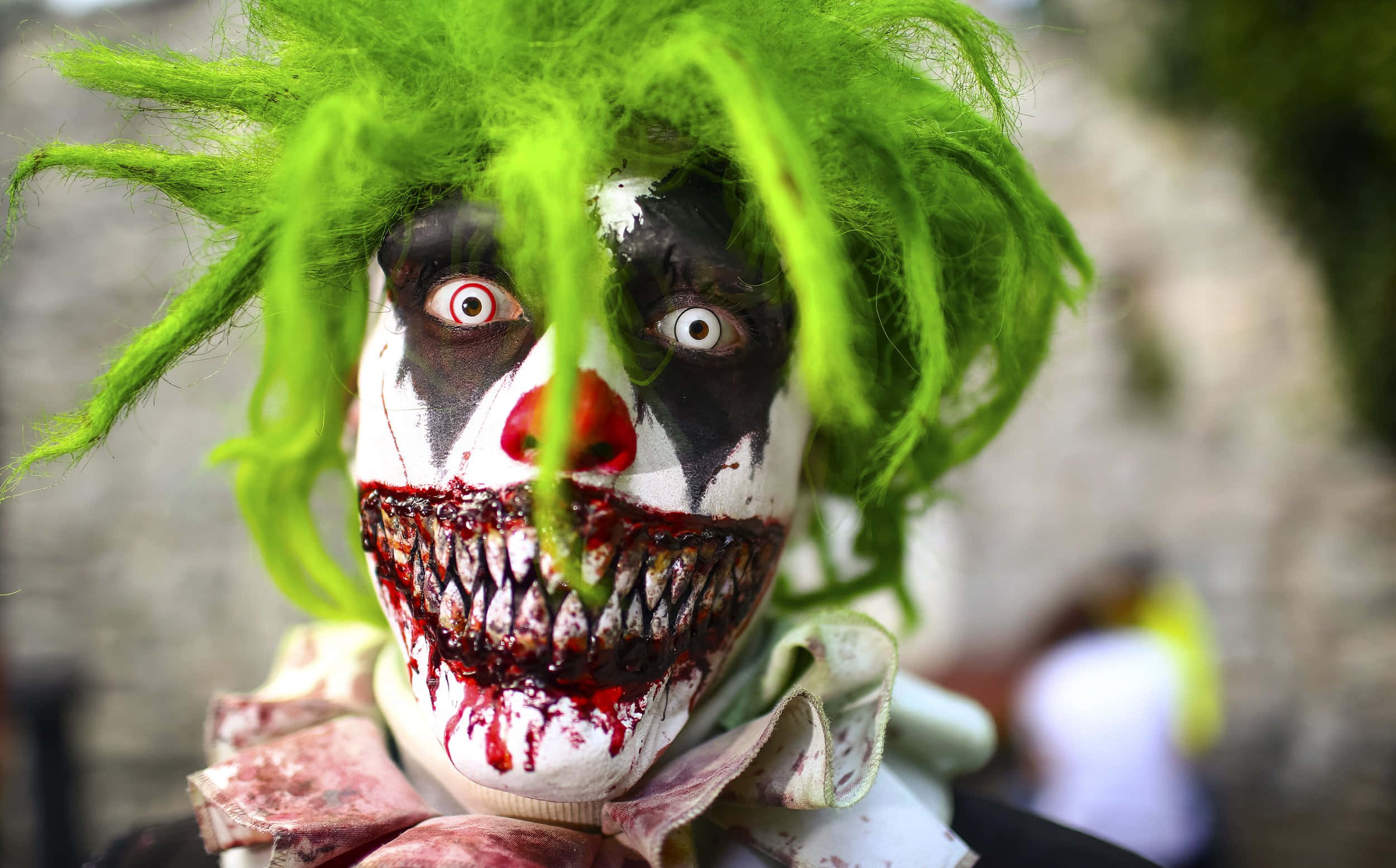 Scary Face 桌布 壁紙 — 一個令人恐懼的小丑特寫，擁有亮綠色頭髮和血淋淋的牙齒，眼神銳利。