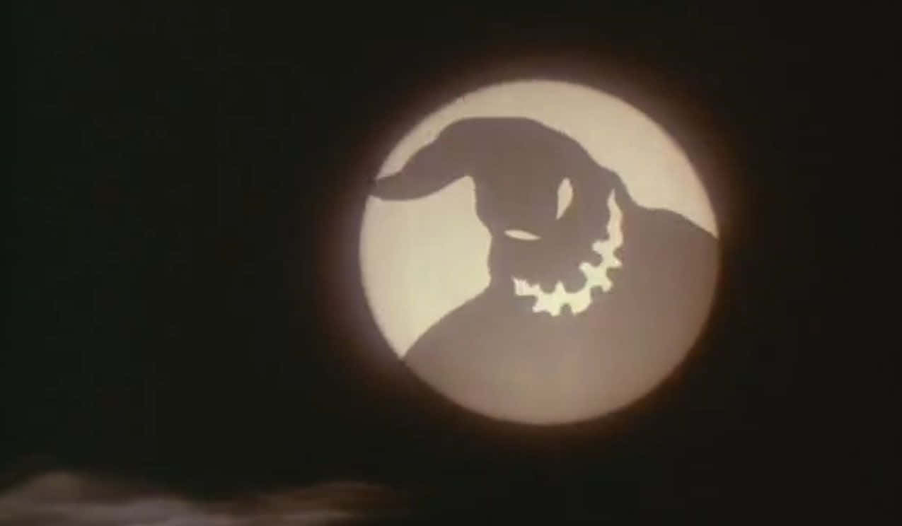 Oogie Boogie 桌布 壁紙 — 一個令人畏懼的傑克南瓜燈面孔剪影在黑暗夜空中的滿月前發光。