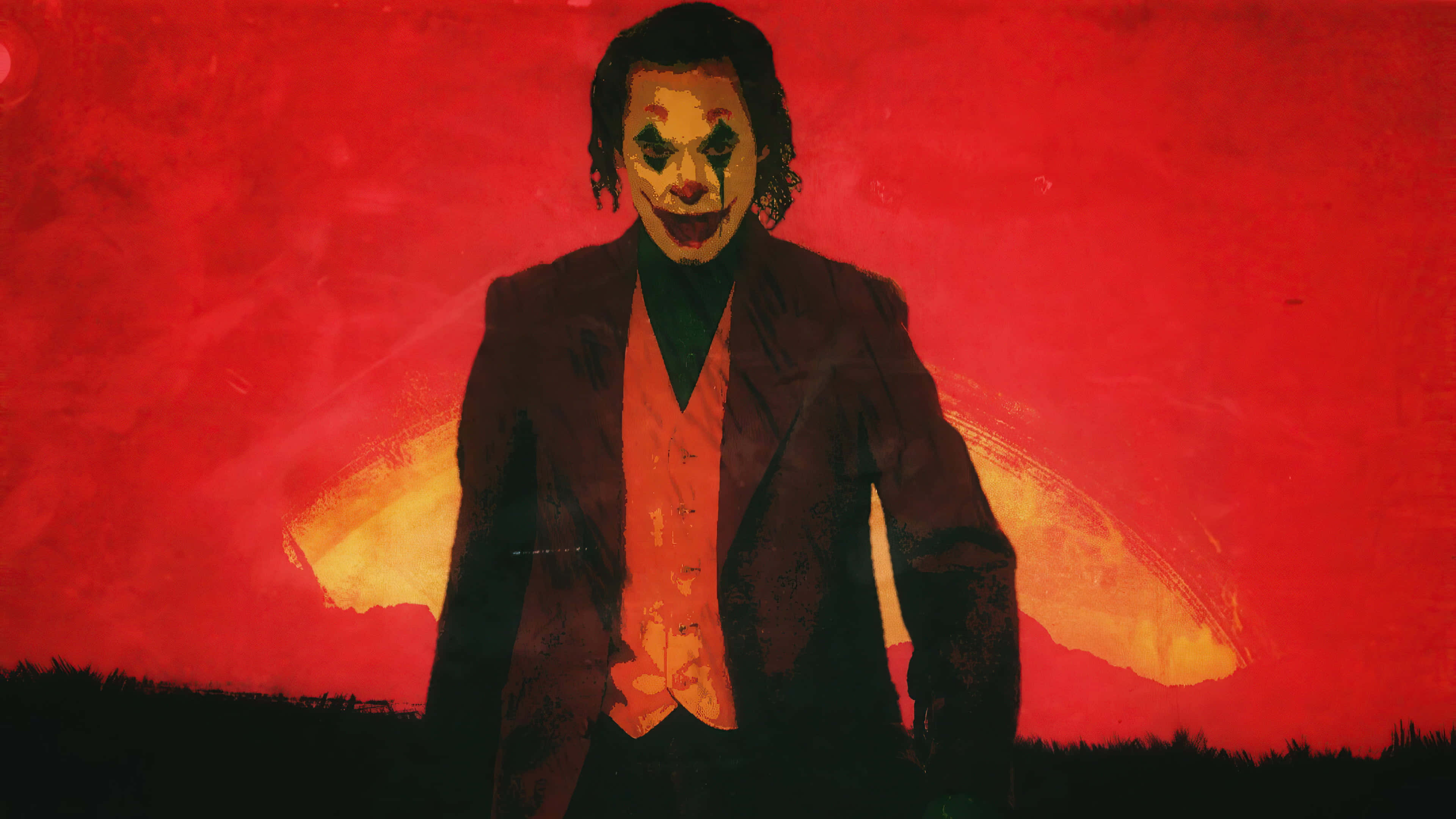 Joker Art 桌布 壁紙 — 一個令人畏懼的小丑站在火紅的背景前，散發著橙色光芒的翅膀，他塗著妝的臉和深色西裝散發出混亂。