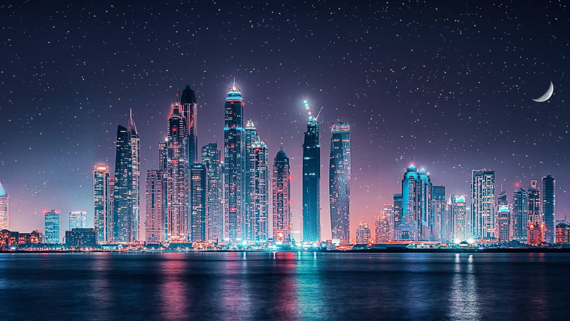 漂亮的桌面 桌布 壁紙 — 一個令人眼花撩亂的夜景，高聳的摩天大樓在星空和彎月下閃耀。