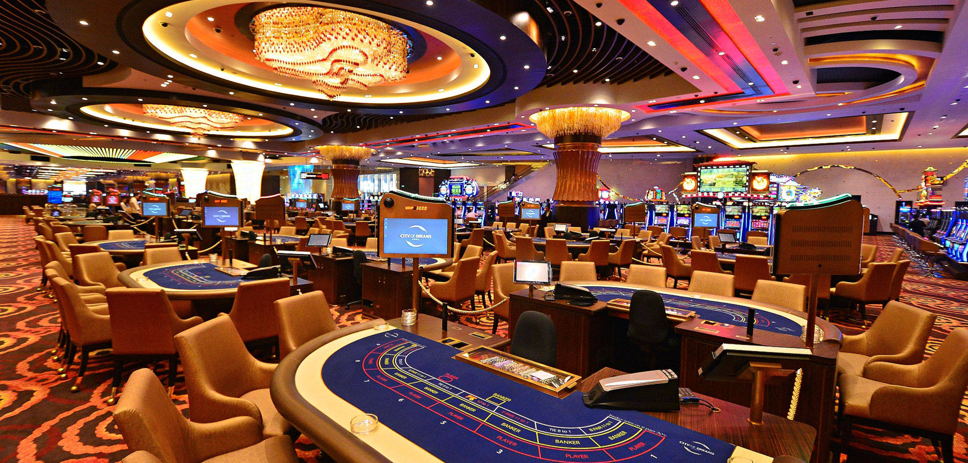 Poker 桌布 壁紙 — 一個令人眼花撩亂的賭場樓層，充滿了發光的老虎機和二十一點賭桌，上方懸掛著宏偉的水晶吊燈。