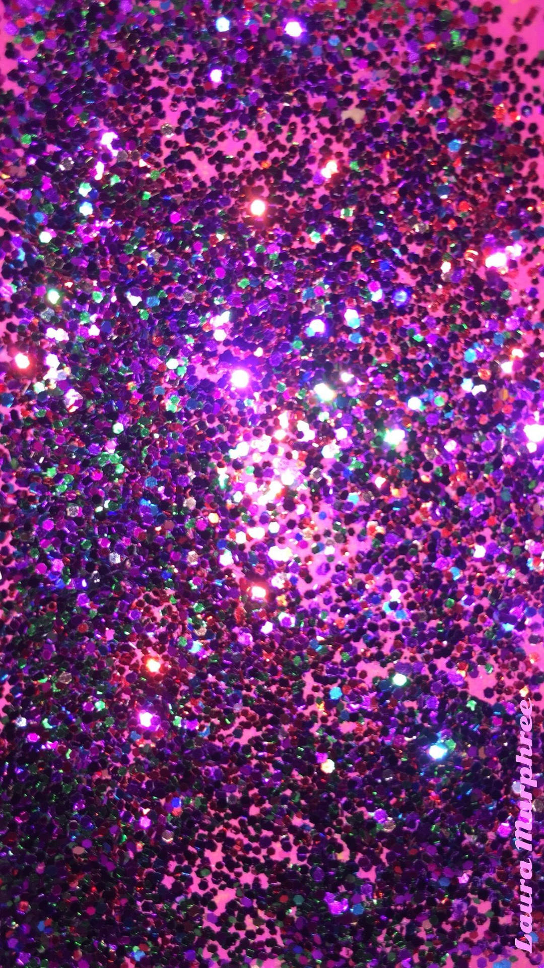 Pink And Blue 桌布 壁紙 — 一個令人眼花繚亂的特寫，展現充滿活力的紫色和粉紅色亮粉顆粒在發光的粉紅色背景上閃爍。