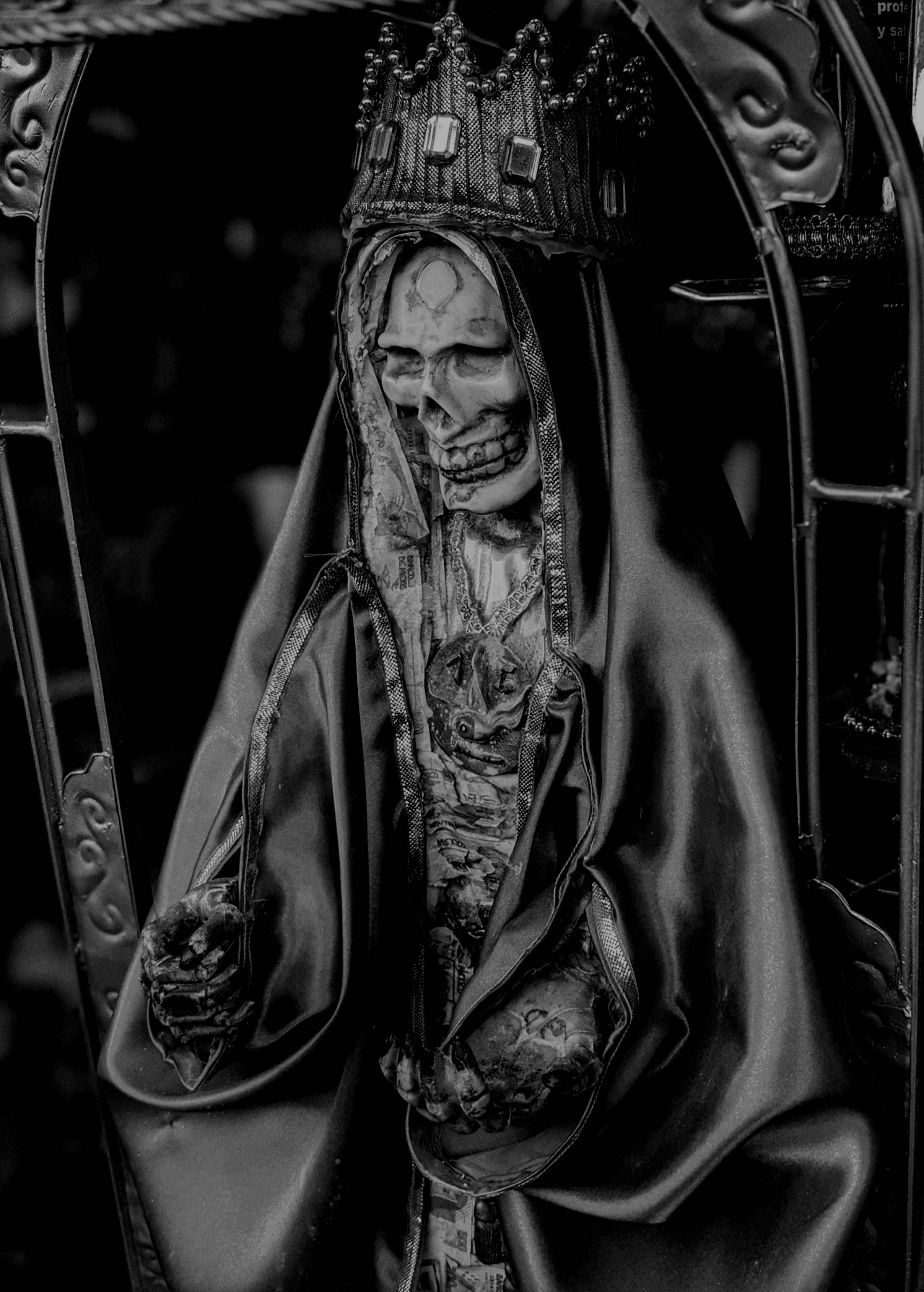 Santa Muerte 桌布 壁紙 — 一個令人難忘的黑白雕像，描繪一個戴著皇冠的骷髏人物，披著流動的長袍，細節精緻。