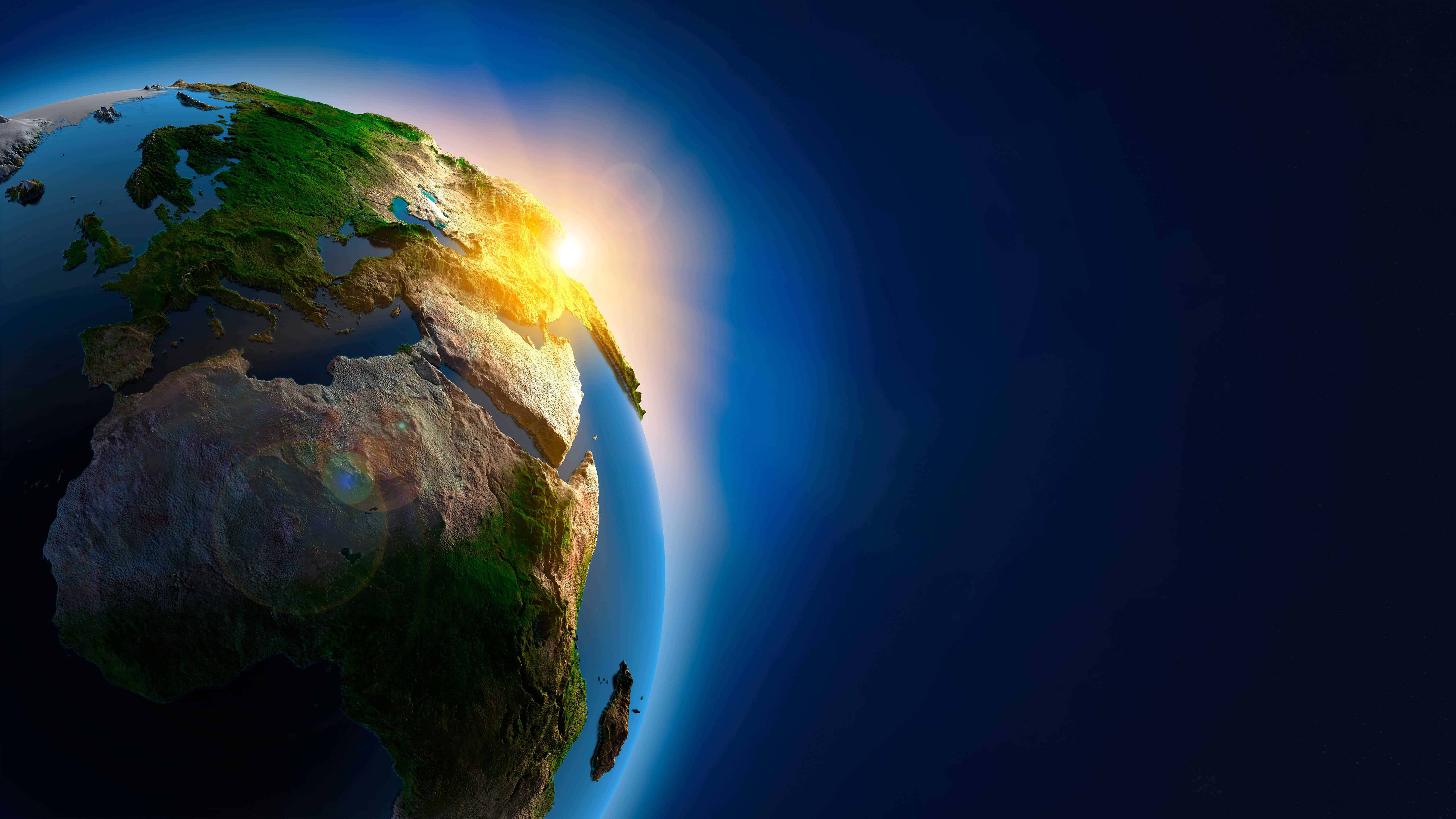 3d Earth 桌布 壁紙 — 一個令人驚嘆的3D渲染地球在日出時，金色光芒照亮大陸和海洋，背景是深藍色太空。