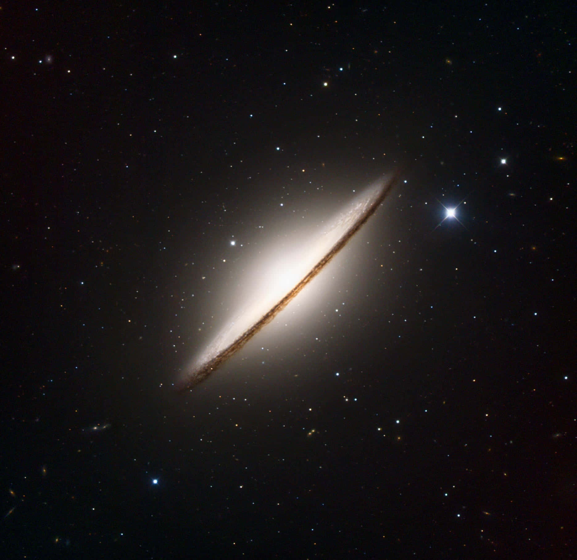 Sombrero Galaxy 桌布 壁紙 — 一個令人驚嘆的側面螺旋星系，在佈滿星辰的宇宙虛空中散發出明亮的白色和金色光芒。