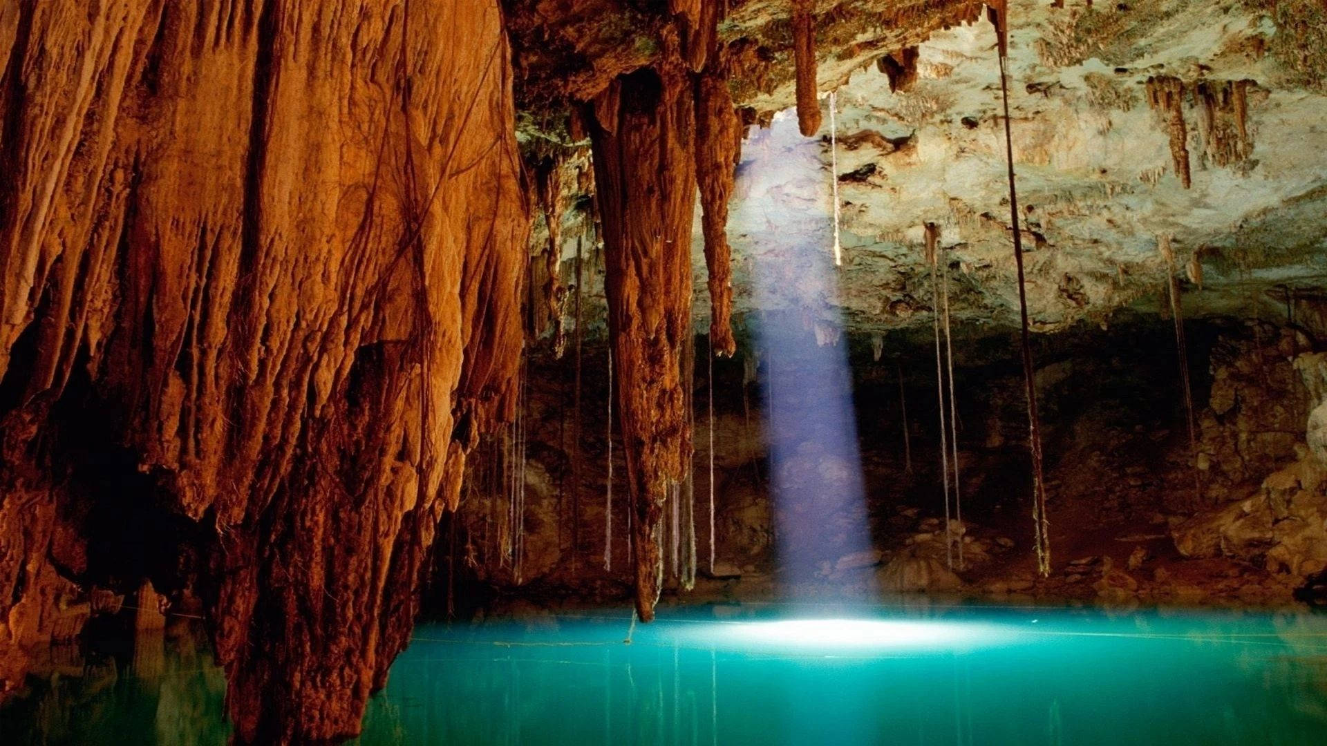 Cave 桌布 壁紙 — 一個令人驚嘆的洞穴，擁有碧綠色的海水，一道陽光從天花板射入水面。