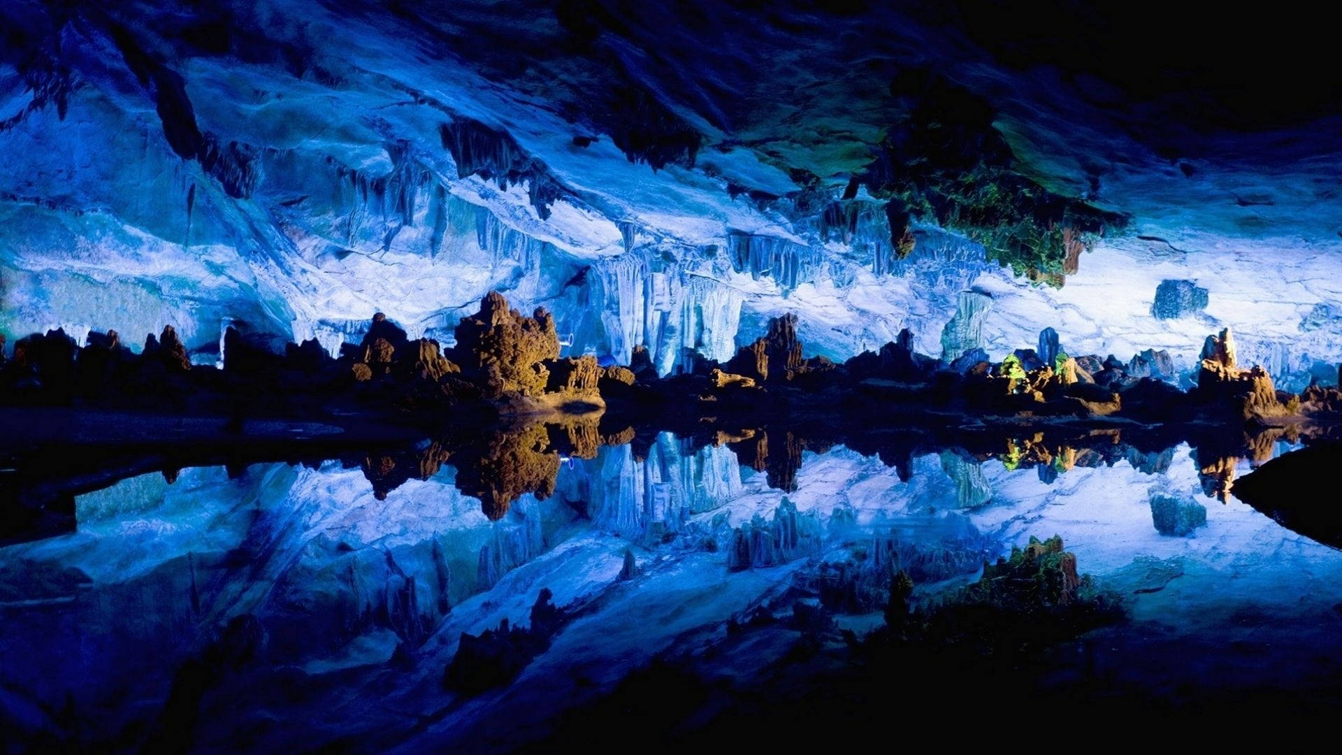 Cave 桌布 壁紙 — 一個令人驚嘆的藍色洞穴，冰凍的鐘乳石和石筍完美地倒映在下方平靜的水面上。