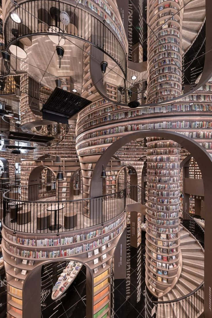 Library 桌布 壁紙 — 一個令人驚嘆的螺旋圖書館，高聳的書架環繞著中央樓梯和拱形走道。