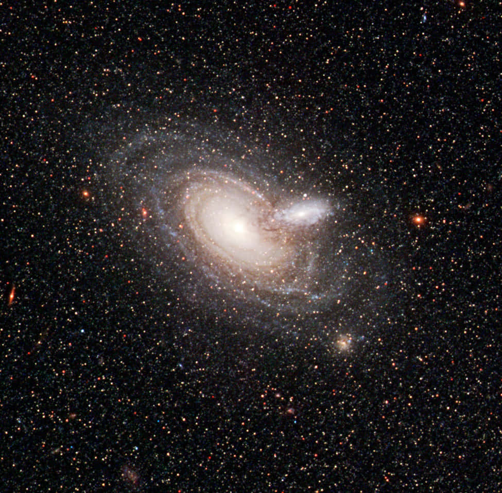 Nasa Galaxy 桌布 壁紙 — 一個令人驚嘆的螺旋星系，具有明亮的核心和旋轉的旋臂，在深空中閃耀於遙遠恆星的星場中。