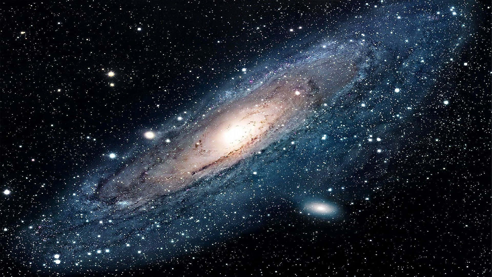 Space Desktop 桌布 壁紙 — 一個令人驚嘆的螺旋星系，在星空中閃耀著藍色和金色的色調。