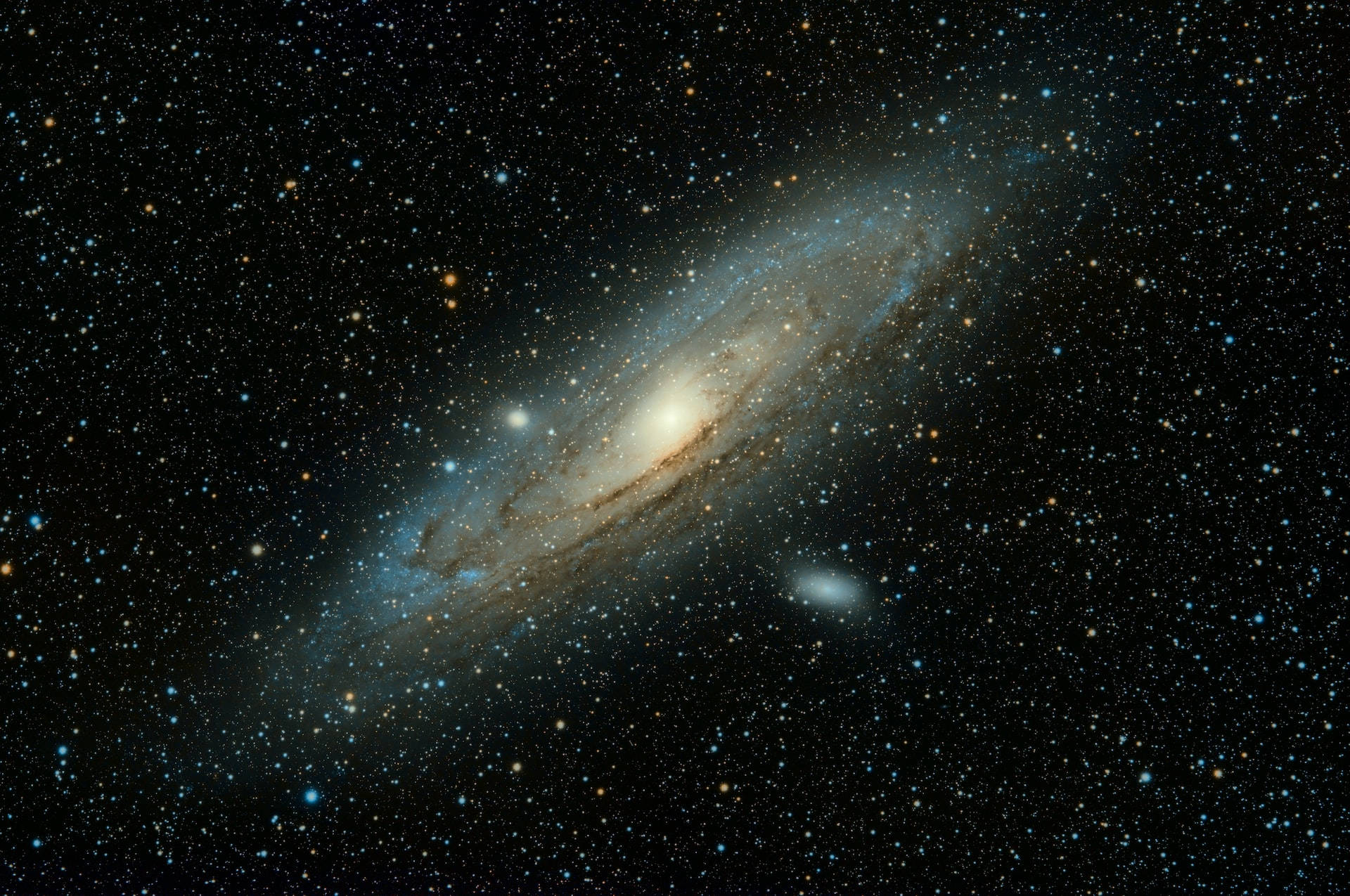 Stars 桌布 壁紙 — 一個令人驚嘆的螺旋星系，在深空的星場中散發出藍色和金色的光芒。