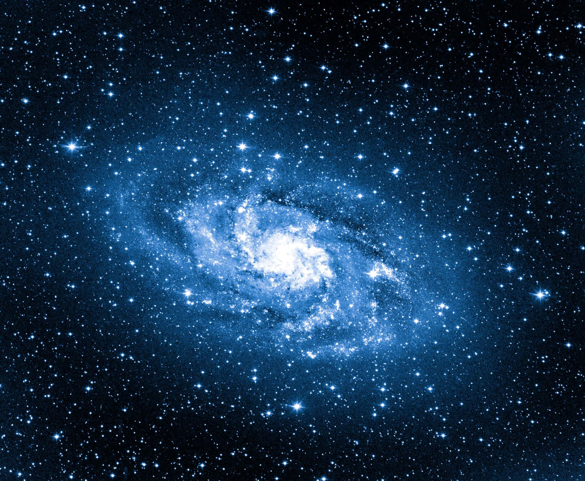 銀河 桌布 壁紙 — 一個令人驚嘆的螺旋星系，在深邃太空的星場中散發出藍色和白色的光芒。