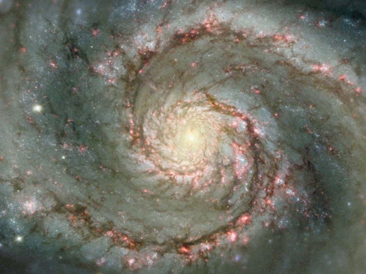 Whirlpool Galaxy 桌布 壁紙 — 一個令人驚嘆的螺旋星系，帶有發光的粉紅色星團和明亮的中心核心，在宇宙背景下旋轉。