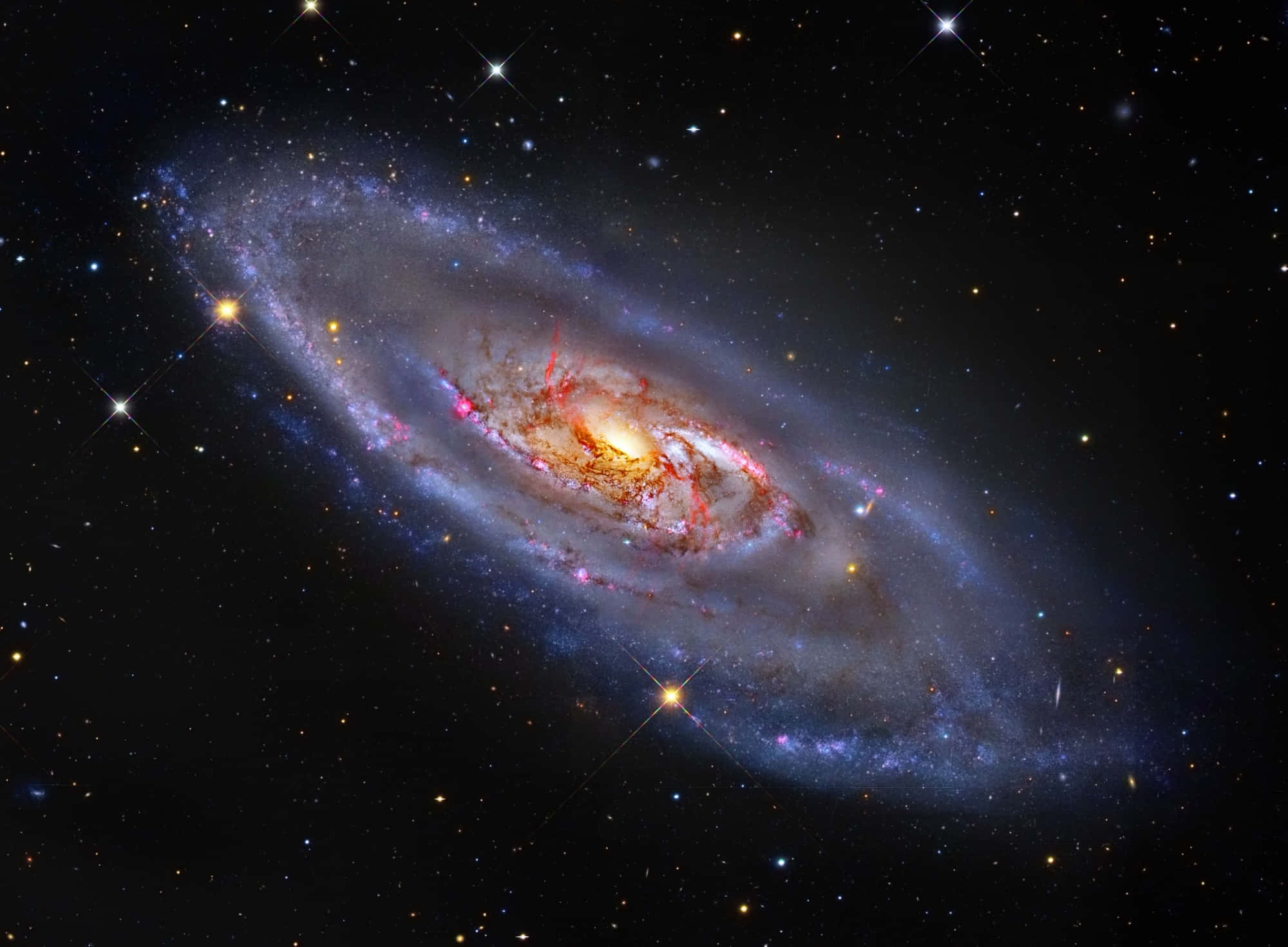 Nasa Galaxy 桌布 壁紙 — 一個令人驚嘆的螺旋星系，帶有發光的橙色核心和藍紫色旋臂，在星場中旋轉。