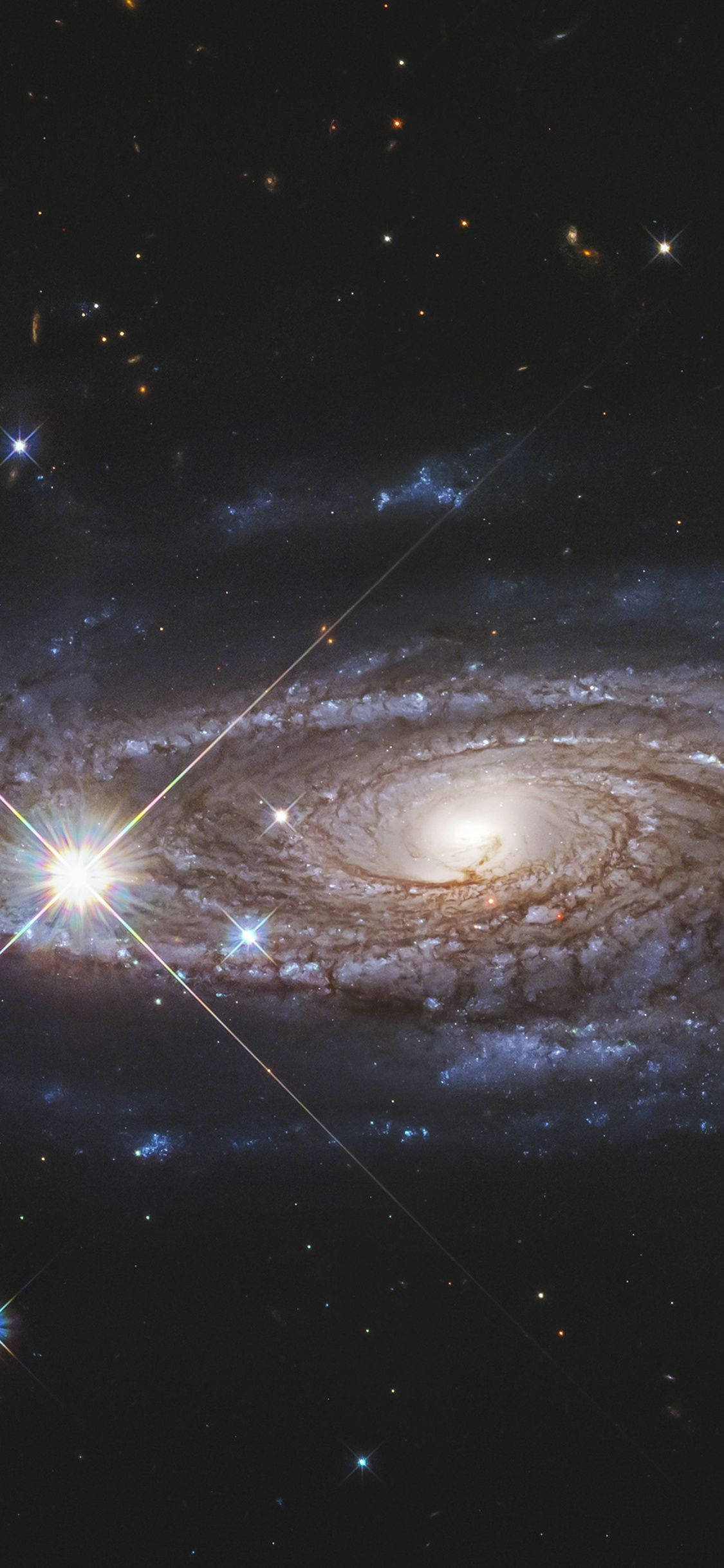 外太空 桌布 壁紙 — 一個令人驚嘆的螺旋星系，帶有發光的旋臂和明亮的星星，背景是深邃的黑色宇宙。