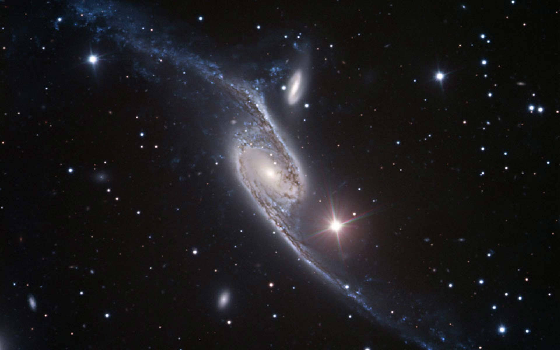 外太空 桌布 壁紙 — 一個令人驚嘆的螺旋星系，帶有發光的旋臂和明亮的星星，背景是深邃的黑色宇宙。