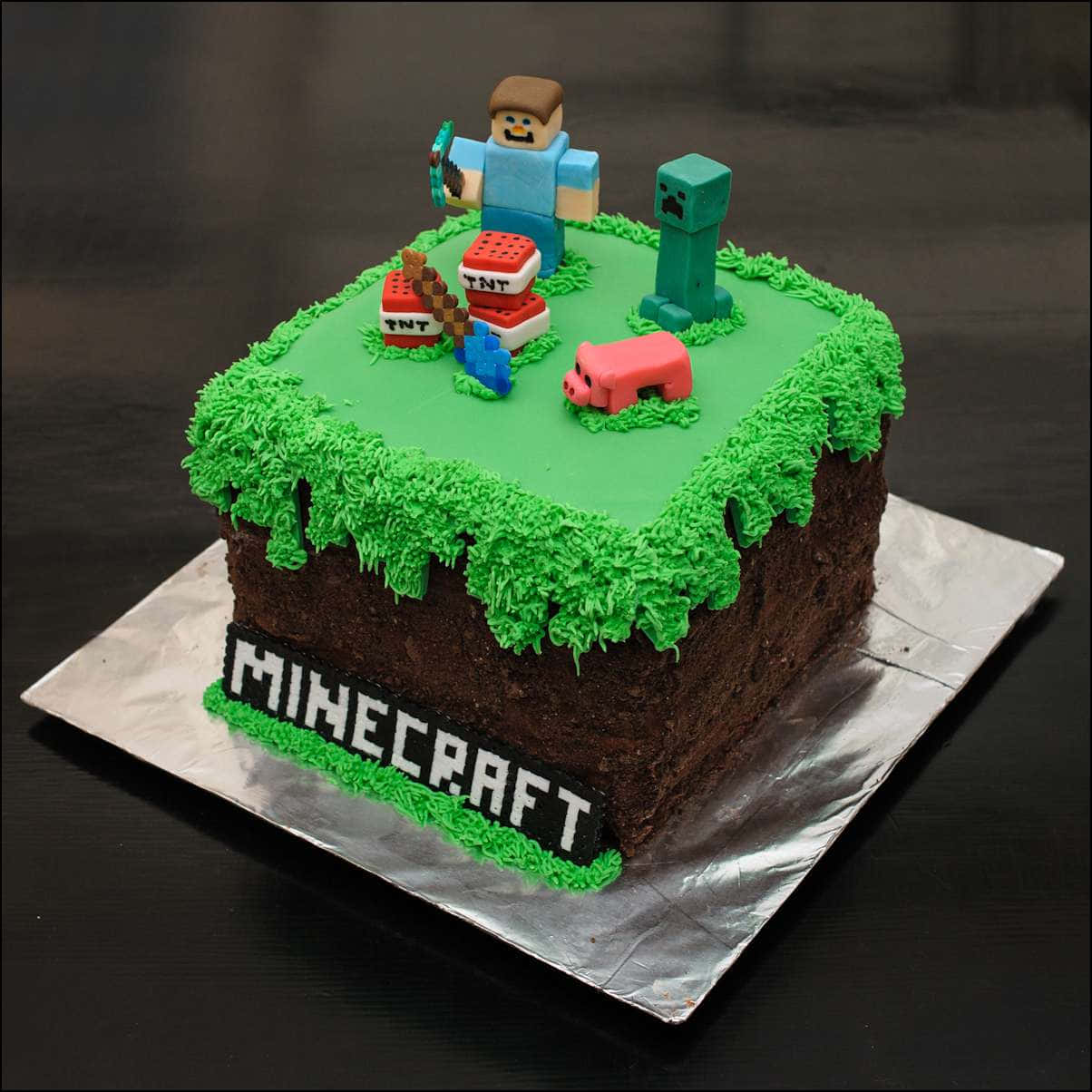 Minecraft Cakes 桌布 壁紙 — 一個以Minecraft為主題的蛋糕，頂部有草和泥土側面，帶有像素化角色和方塊。