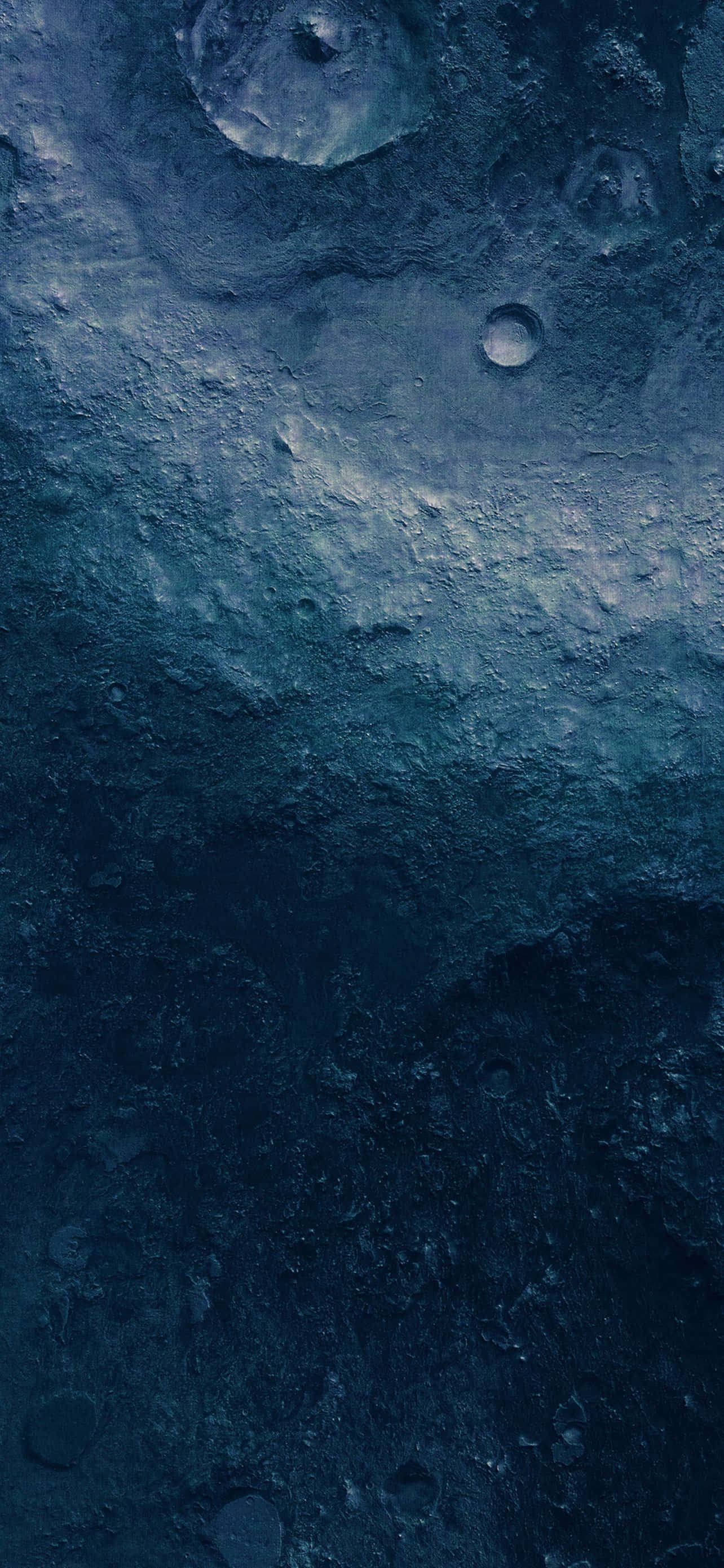 Blue iPhone 桌布 壁紙 — 一個佈滿隕石坑的月球表面特寫，沐浴在深藍色和灰色調中，帶有微妙的高光。
