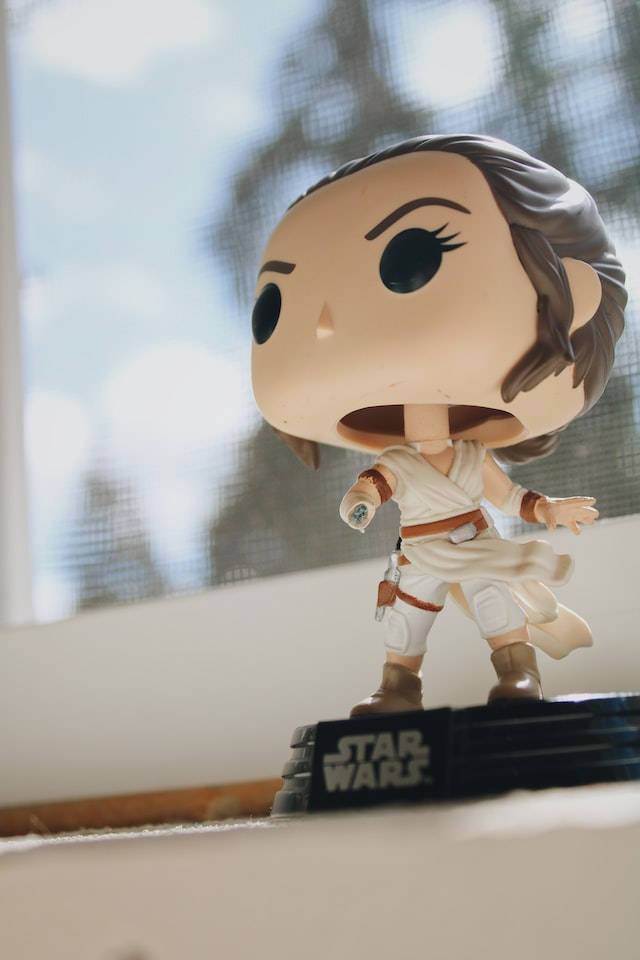 星際大戰 iPhone 桌布 壁紙 — 一個來自《星際大戰》的芮Funko Pop!人偶站在窗台上，柔和自然光透過紗窗照射進來。