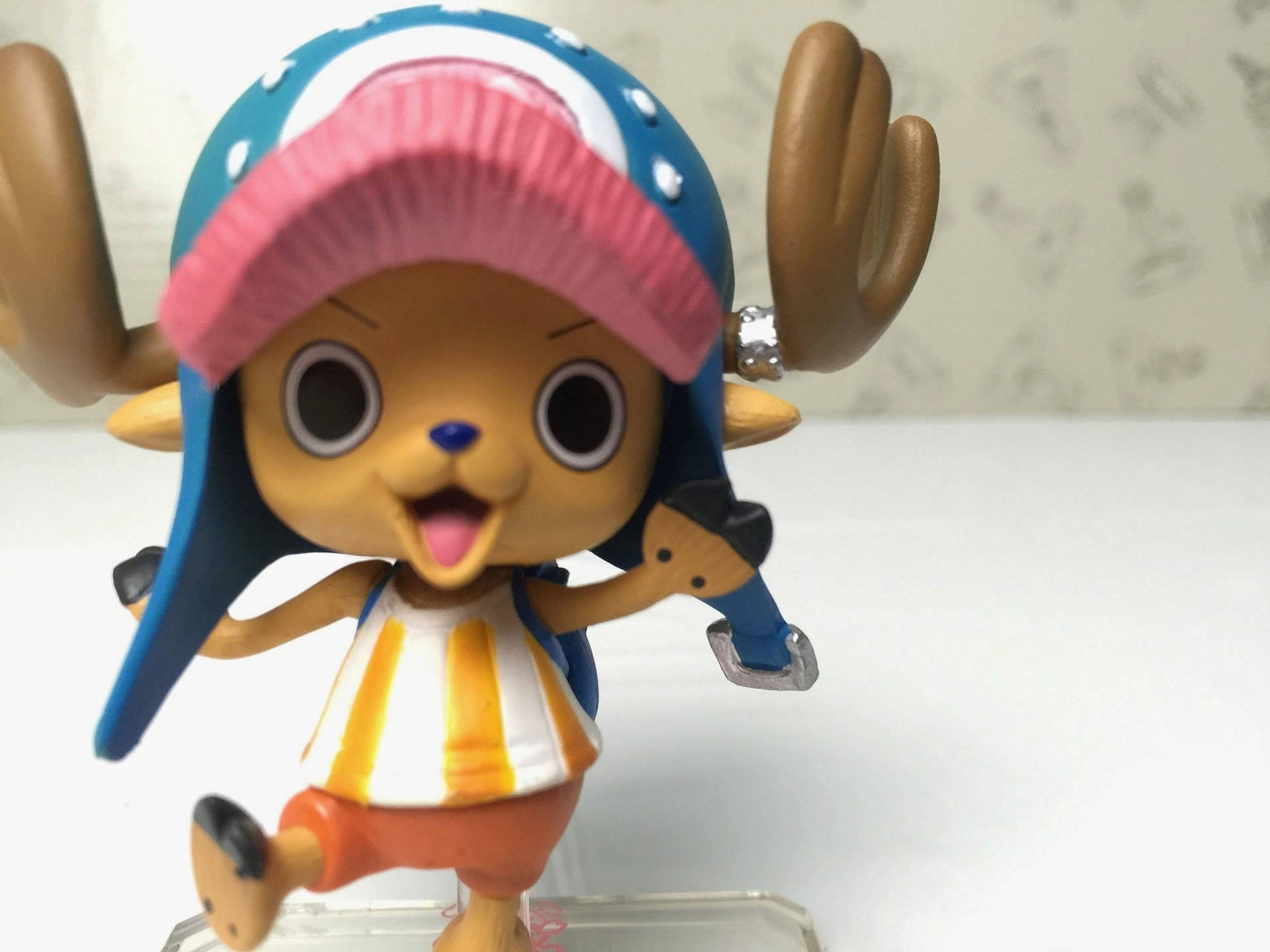 one piece art 桌布 壁紙 — 一個來自《航海王》的東尼東尼喬巴的開心Q版公仔，戴著標誌性的藍粉帽子和條紋襯衫。