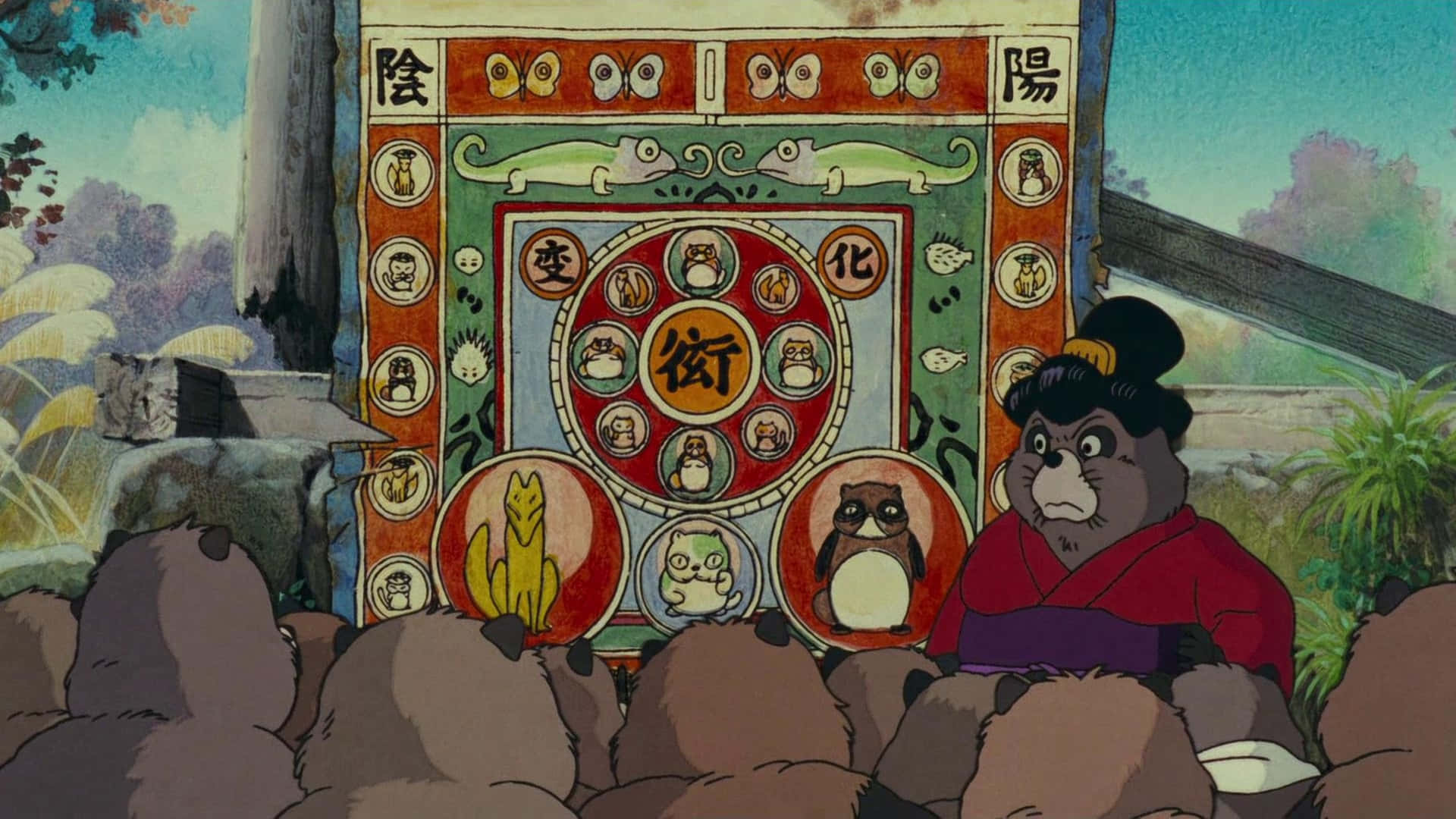 pom poko 桌布 壁紙 — 一個傳統的日本動畫場景，一隻熊僧侶向一群毛茸茸的生物展示一個色彩繽紛的陰陽圖。