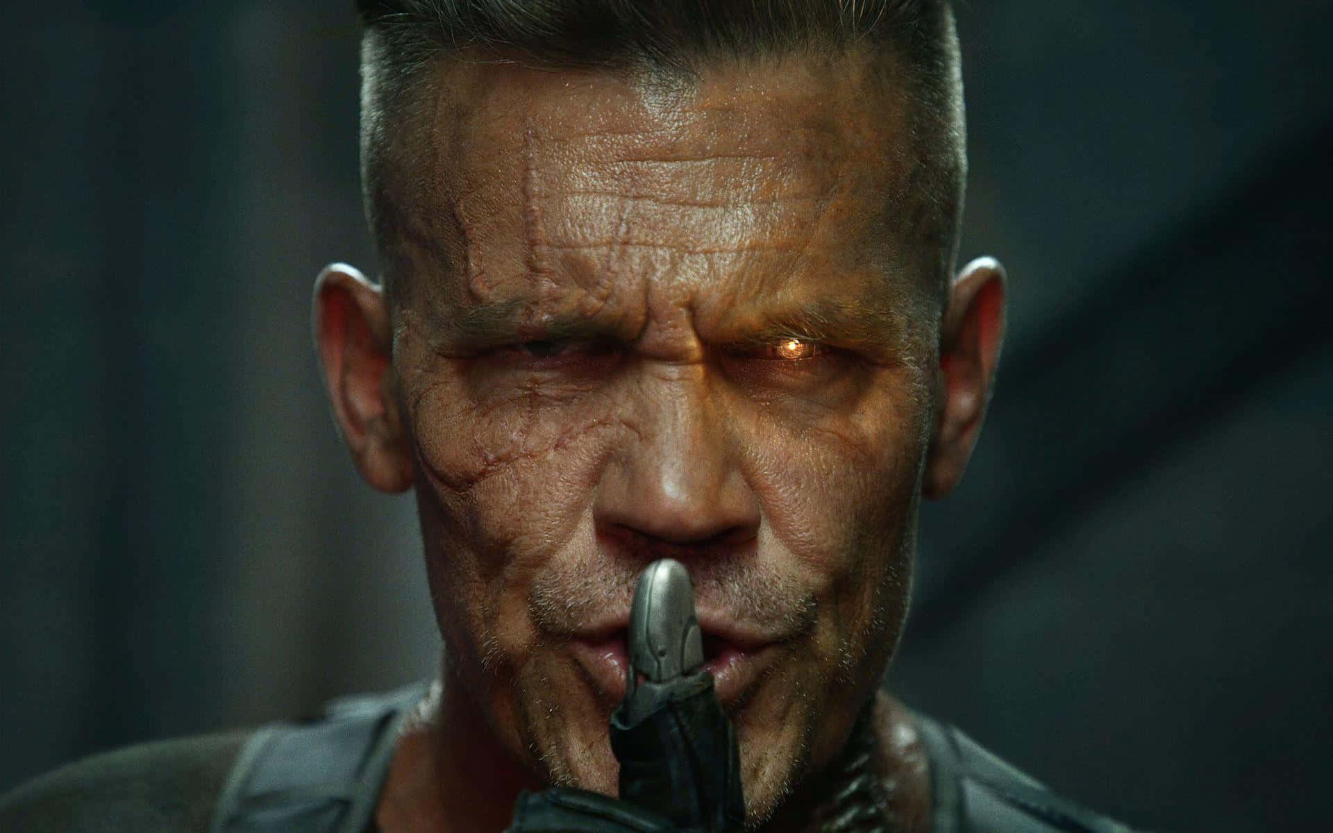 Deadpool 2 桌布 壁紙 — 一個傷痕累累的男人，在黑暗環境中，用發光的橙色眼睛將刀刃貼在嘴唇上的粗獷特寫。